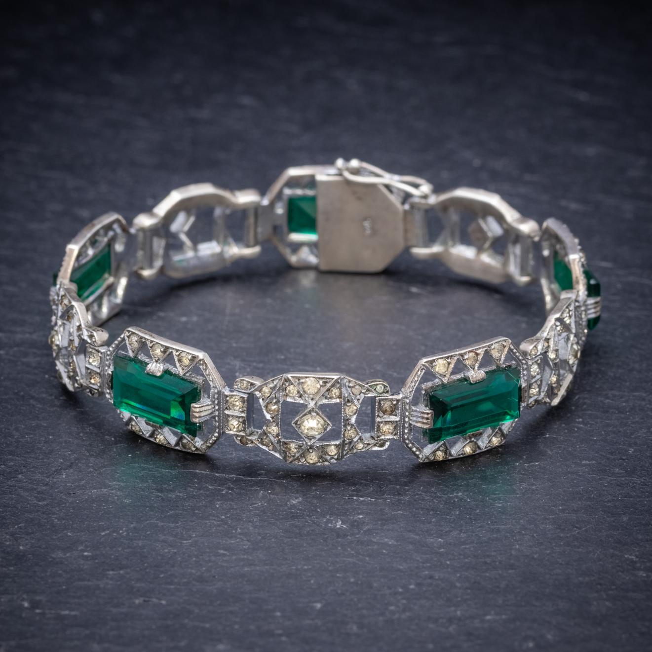 This fabulous Art Deco bracelet is decorated with sparkling white Paste Stones and larger emerald cut Pastes that have the deep green allure of Emeralds. 

The piece is all set in Sterling Silver and fitted with a secure box clasp and safety catch.