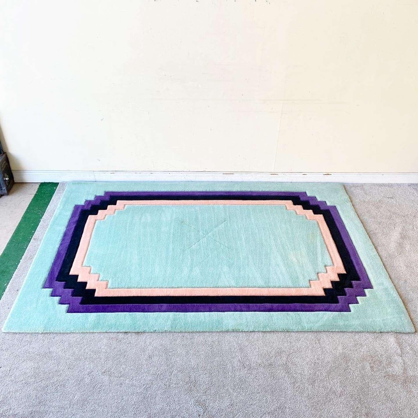 Amazing vintage art deco/postmodern rectangular area rug. Features a minty green interior and outer edge bordered by purple, black and pink sculpted stripes.

Rug 43
