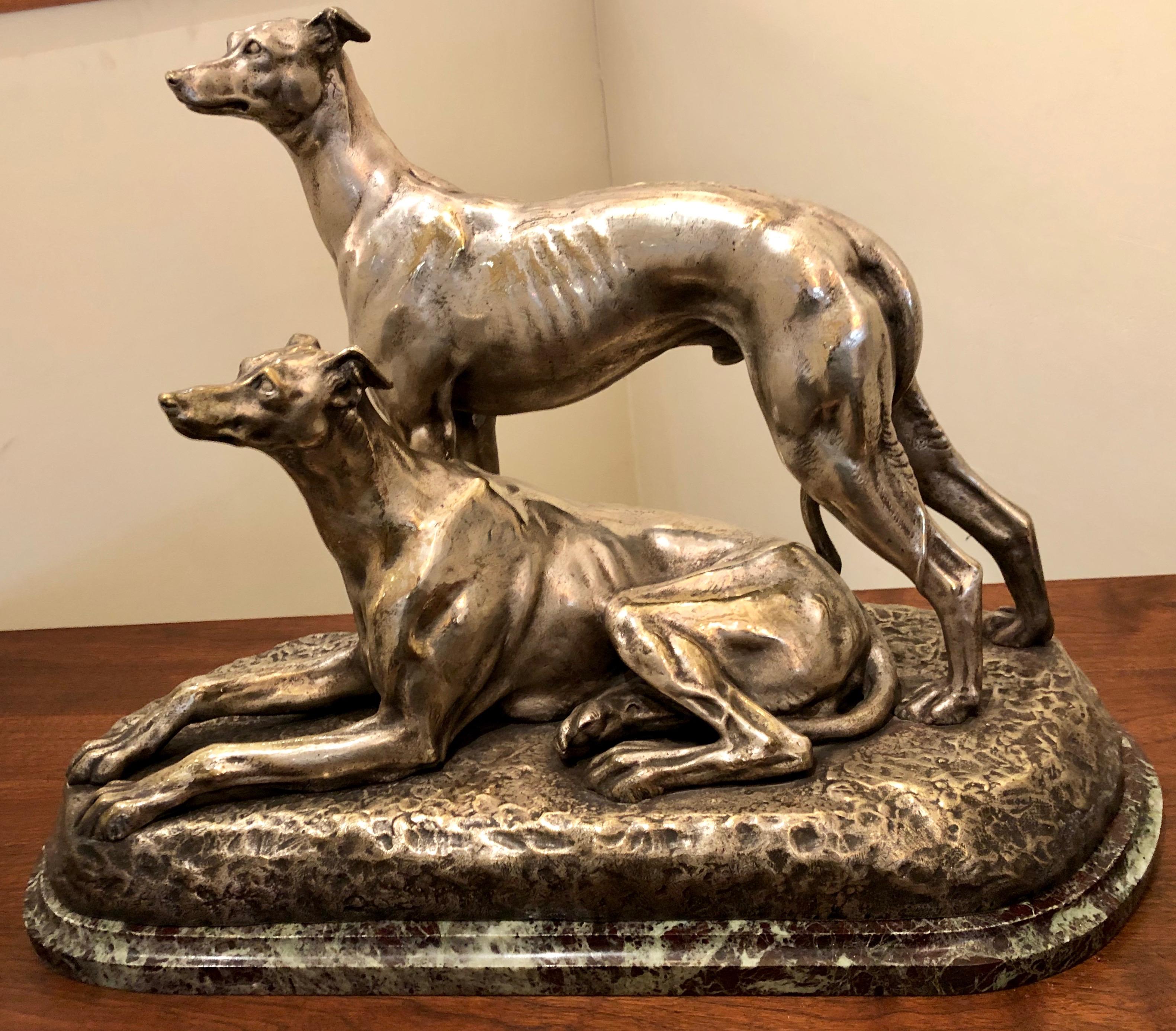 Two greyhound dogs, a nickeled bronze sculpture by French artist Suzanne Bizard. Stylized figural and accurate rendering portraying a pair of greyhound dogs relaxed in situ. Stunning quality showing the many physical characteristics of this breed: