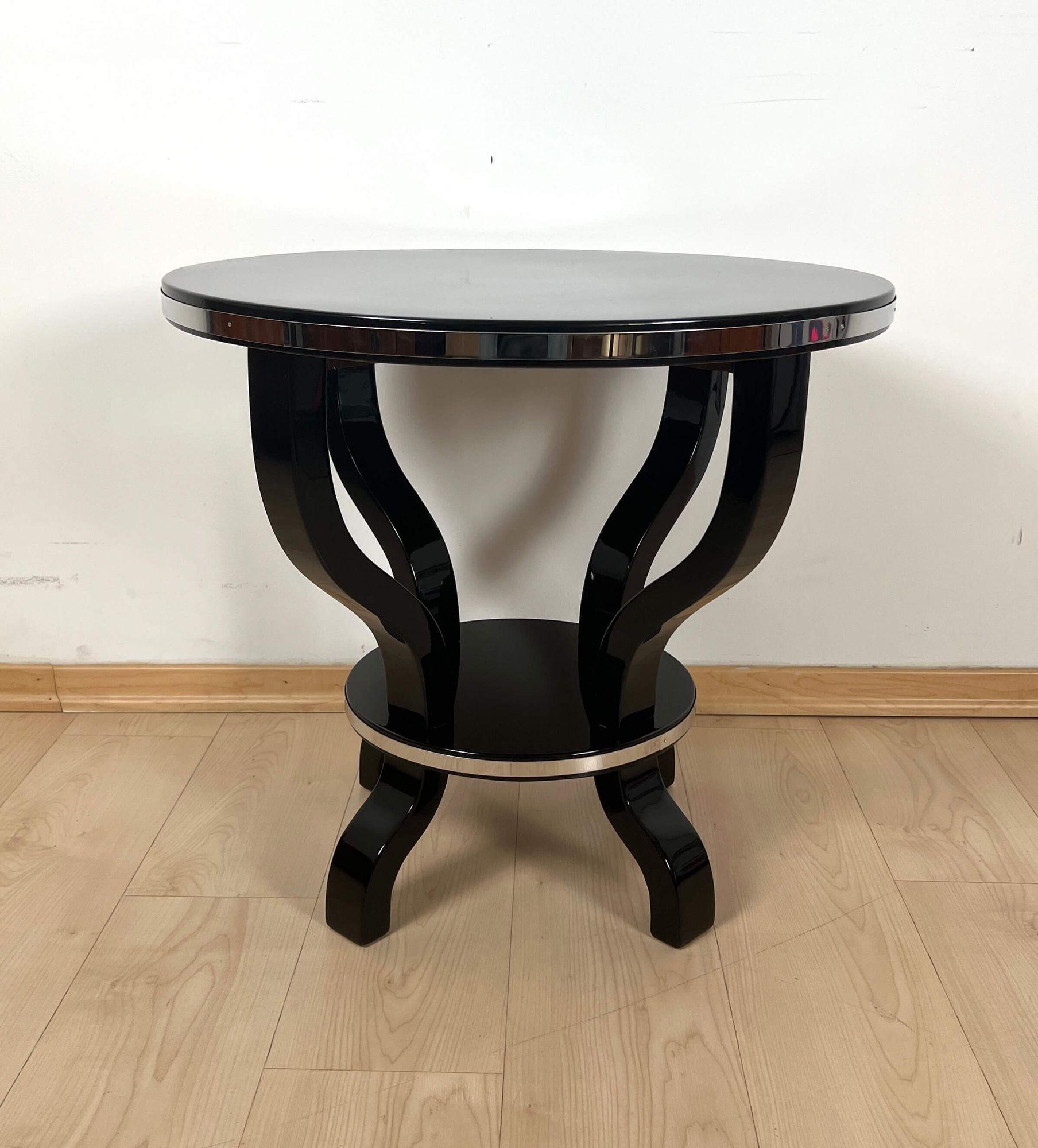 Original Art Deco round four-legged side table or gueridon.

* Wood, black lacquered with piano lacquer and polished to high gloss.
* Two polished stainless steel trims around top and intermediate tableau.
Dimensions: H 60 cm x Ø 60 cm.