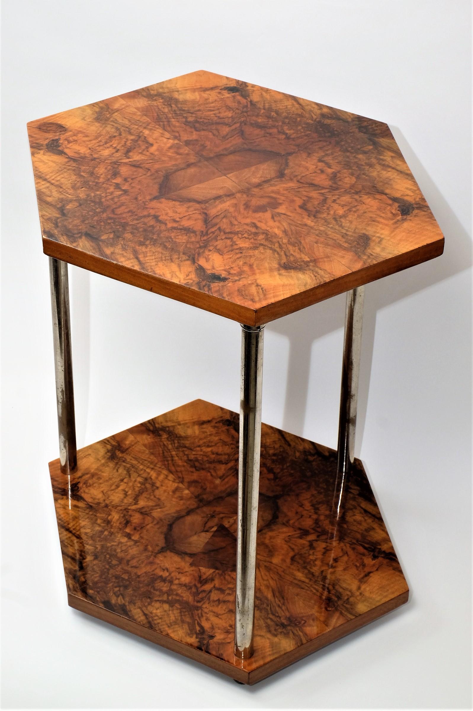 Rare Art Deco side table with two hexagonal walnut boards and three chromed iron legs. The table stands on three black ball feet.

This piece is in a good vintage condition with traces of wear. The chrome plating of the legs has come loose in some