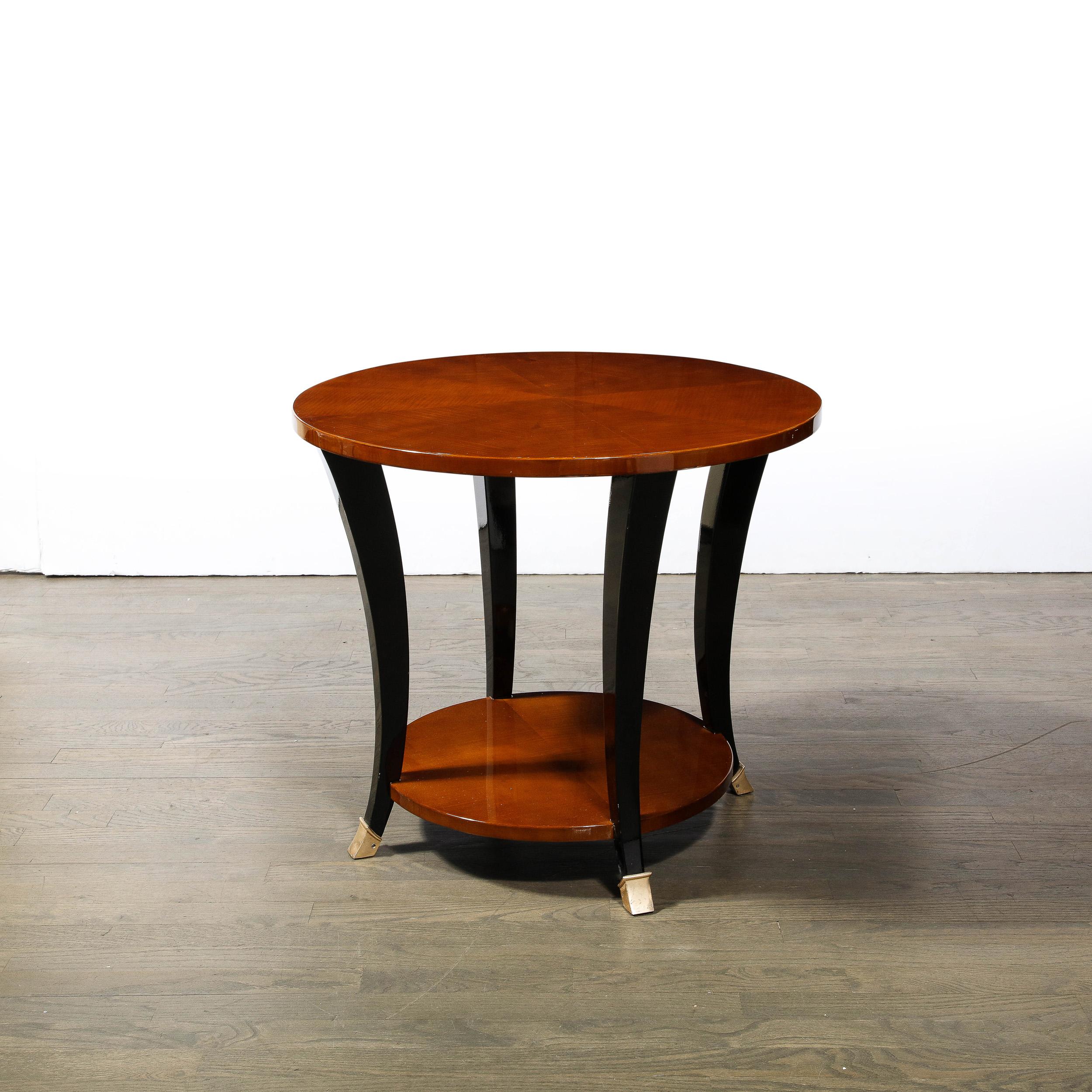 This beautiful two tier Art Deco Machine Age Gueridon table was realized in France circa 1935. It offers two circular table tops in bookmatched walnut (showcasing the rich natural beauty of the woodgrain) connected by streamlined subtly bowed