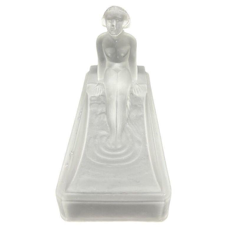 Diese Neuauflage einer Art-Deco-Seifenschale/Ringschale aus Milchglas von Heinrich Hoffman aus dem Jahr 1927 aus den 1980er Jahren zeigt eine nackte weibliche Figur, die in einer Wanne badet.

Diese Re-Edition ist signiert und wird von Sarsaparilla