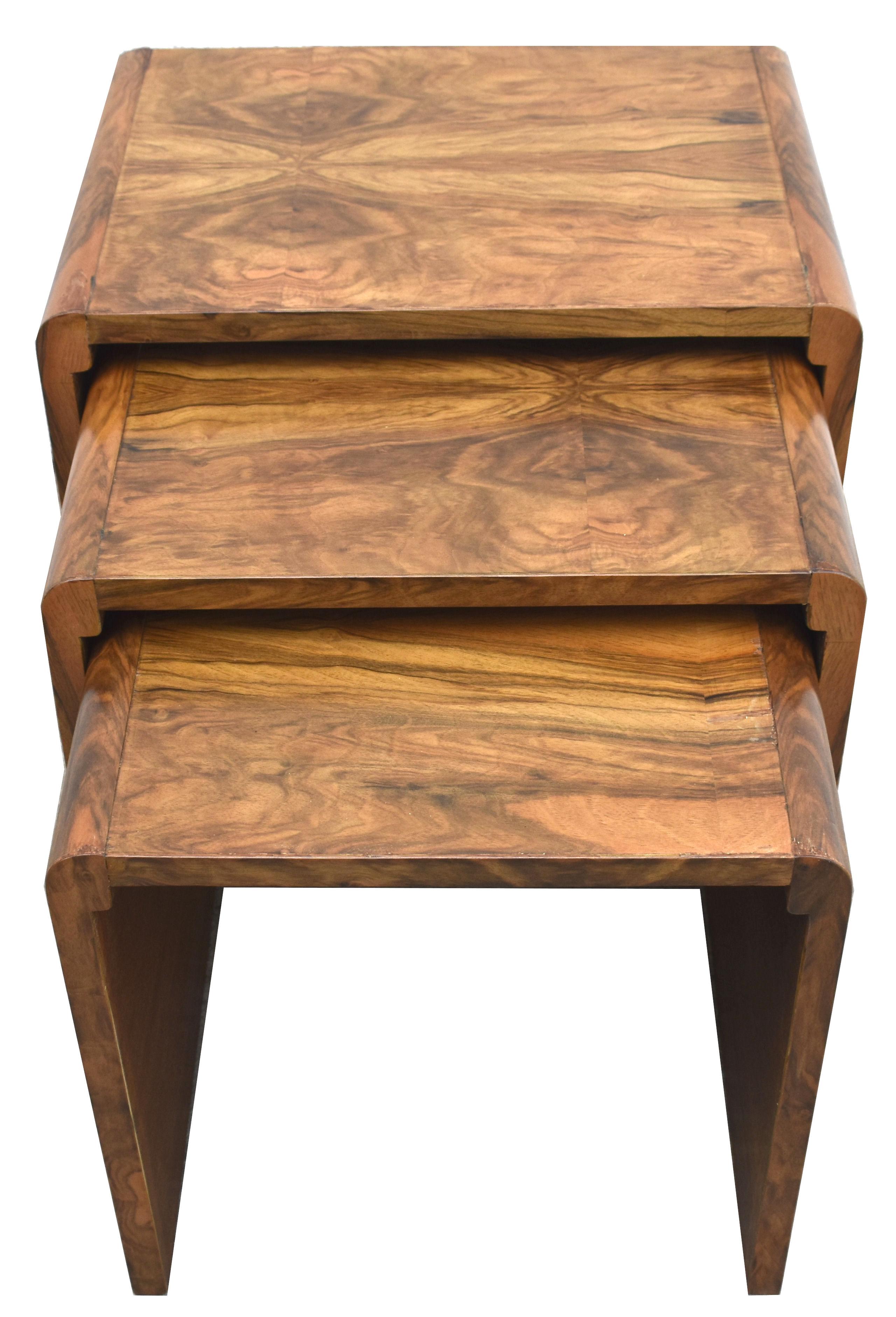 A very stylish and distinctive Art Deco nest of walnut tables dating to the 1930s and made by H & L Epstein a highly regarded furniture maker of the period. One large table with two further tables in tiered sizes that snugly fit underneath each