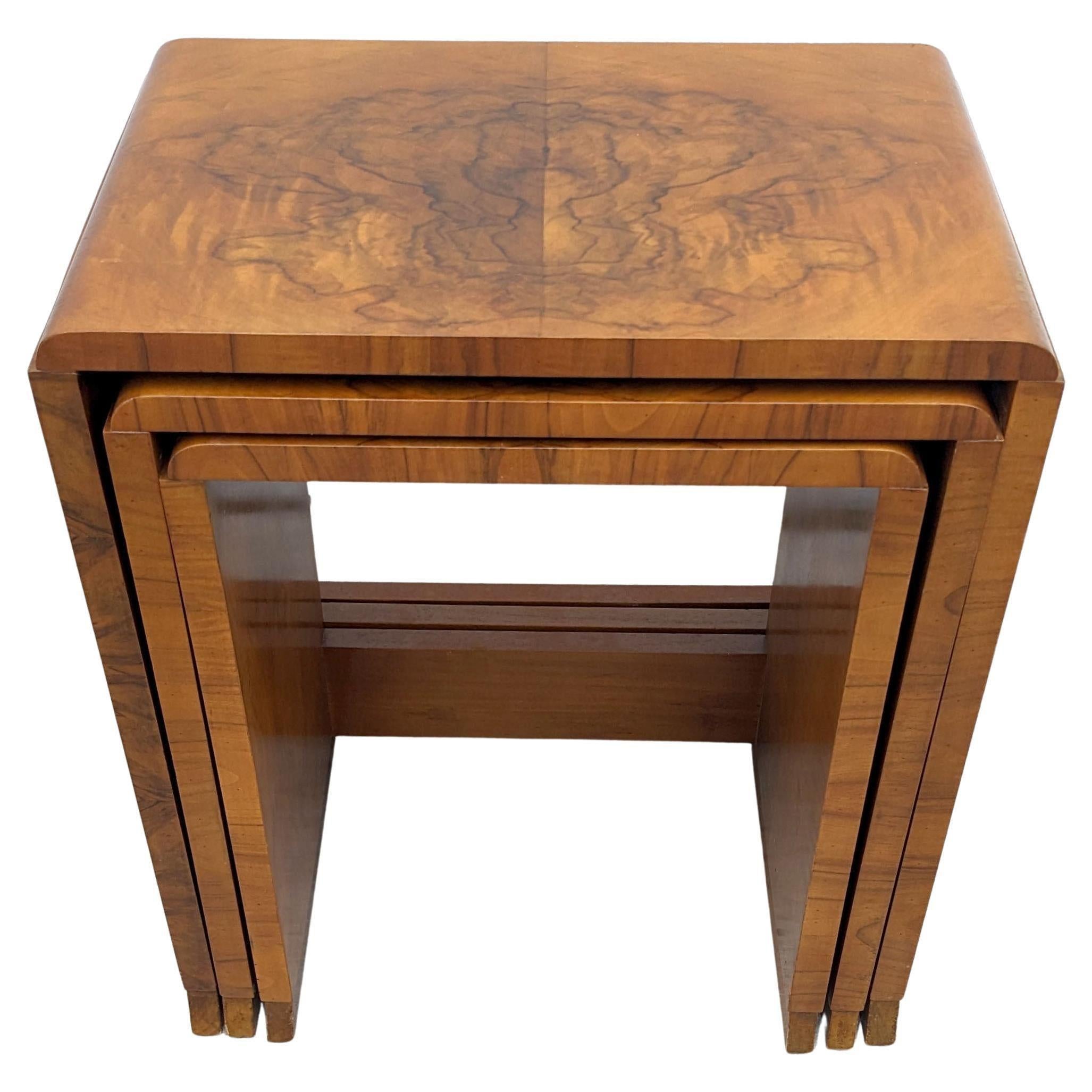 A very stylish and distinctive Art Deco nest of walnut tables dating to the 1930s and made by H & L Epstein a highly regarded furniture maker of the period. One large table with two further tables in tiered sizes that snugly fit underneath each
