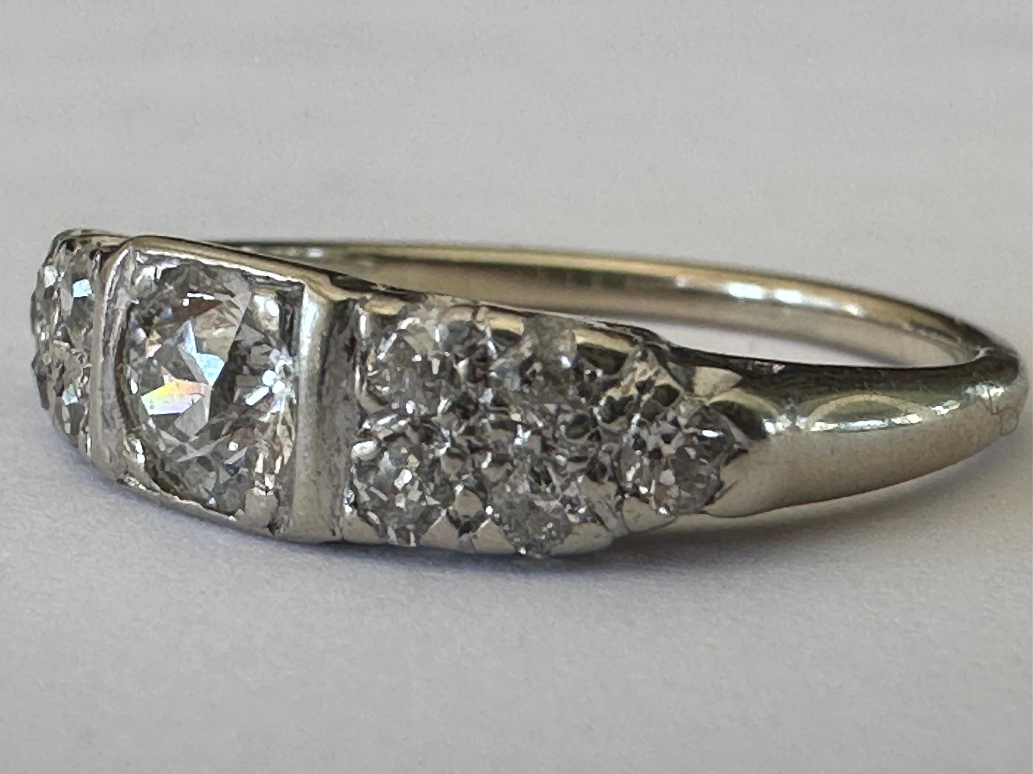 Ein Diamant im alten europäischen Schliff mit einem Gewicht von ca. 0,40 Karat, Farbe G, Reinheit VS, wird auf jeder Seite von fünf kleineren Diamanten im alten europäischen Schliff mit einem Gewicht von insgesamt ca. 0,20 Karat akzentuiert.