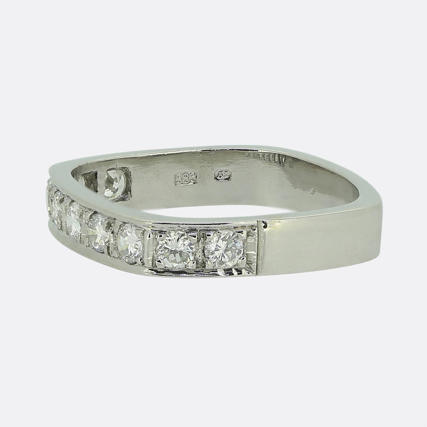 Here we have a delightful half-eternity ring crafted at a time when the Art Deco style was continuing to revolutionise the world of design. This 14ct white gold piece showcases an alternate square shaped band which plays host to a single row of