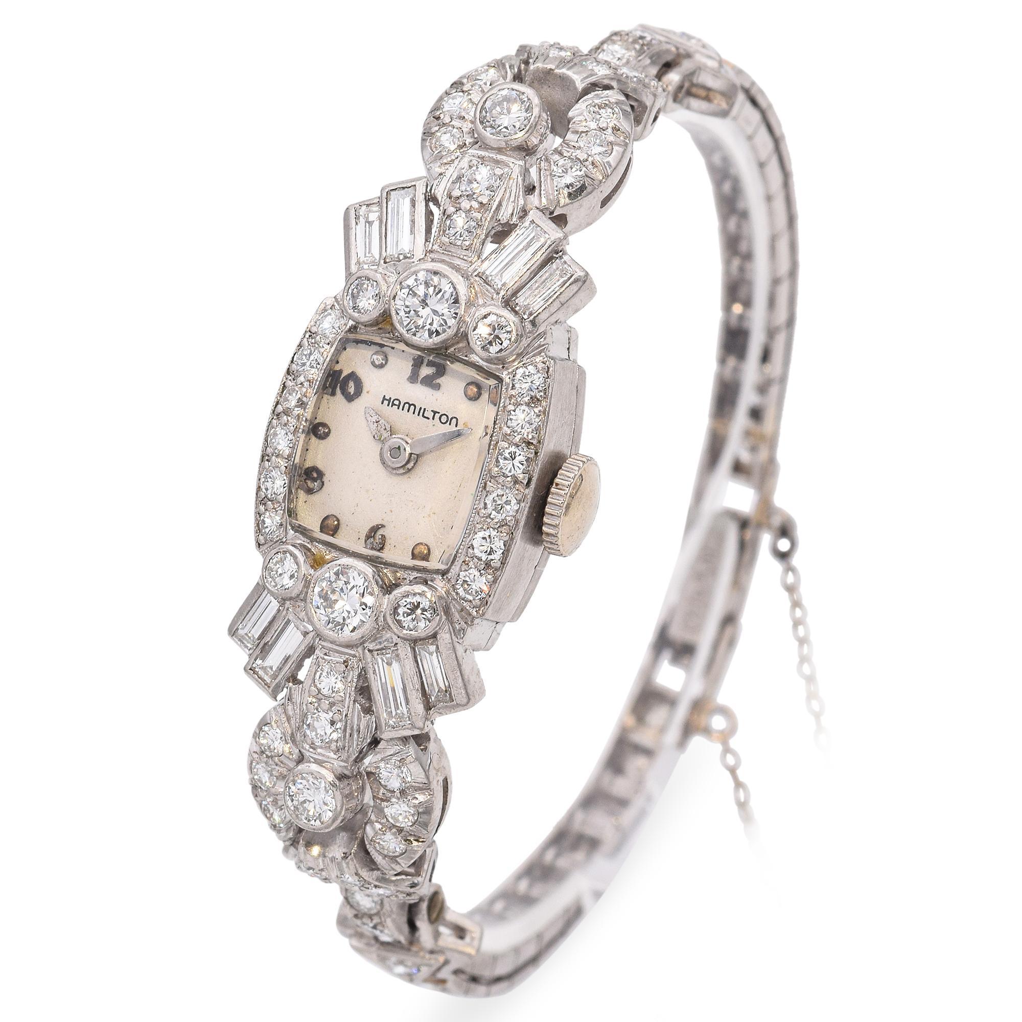 A stunning creation by Hamilton, this exquisite timepiece showcases a captivating array of sparkling diamonds. The watch face is elegantly framed by a series of round and baguette-cut diamonds, meticulously set in platinum. The intricate design