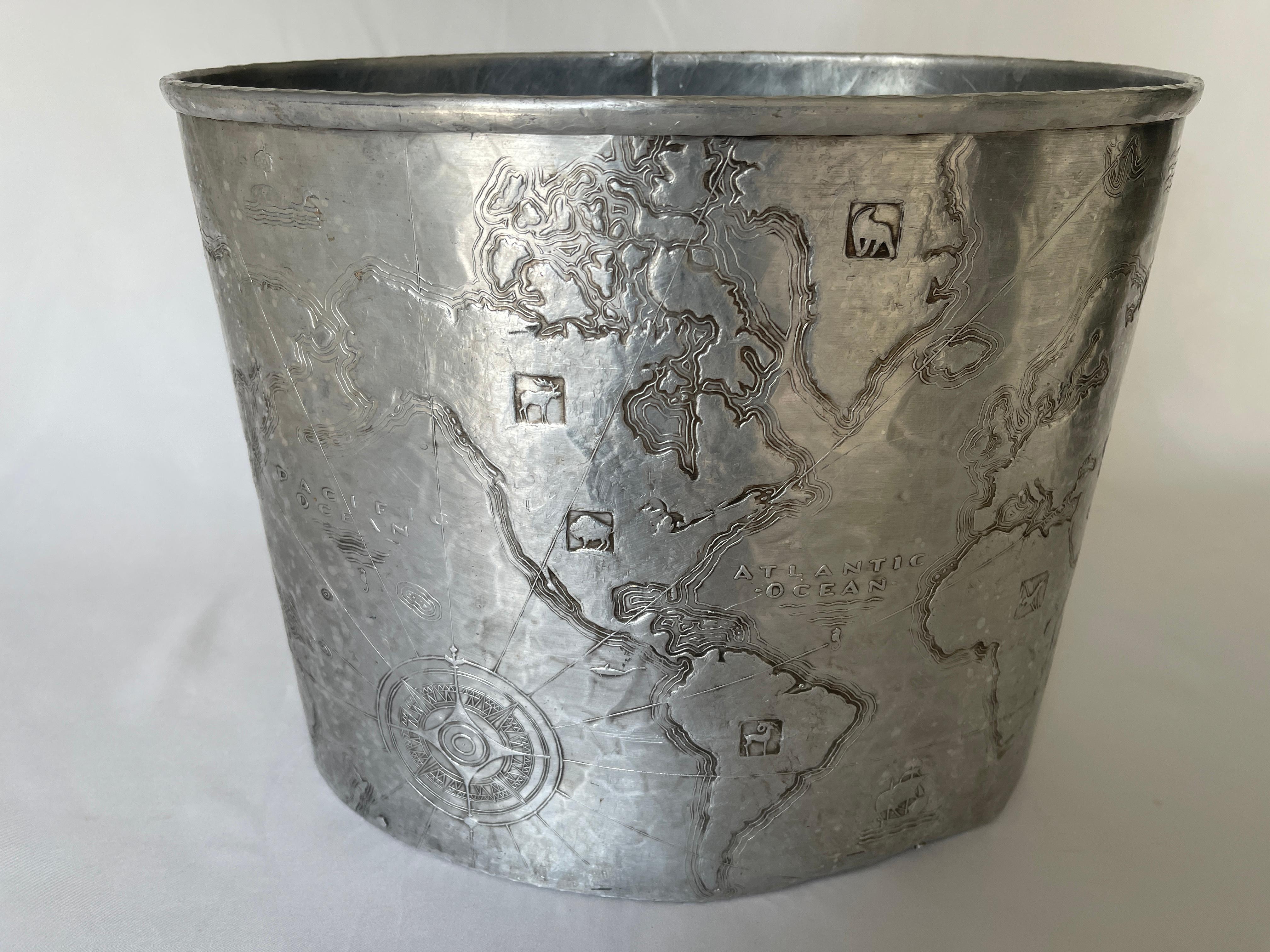 Art Deco hand hammered aluminum map of the world oval wastebasket 
by Arthur Armour, c. 1930's. As found condition.
