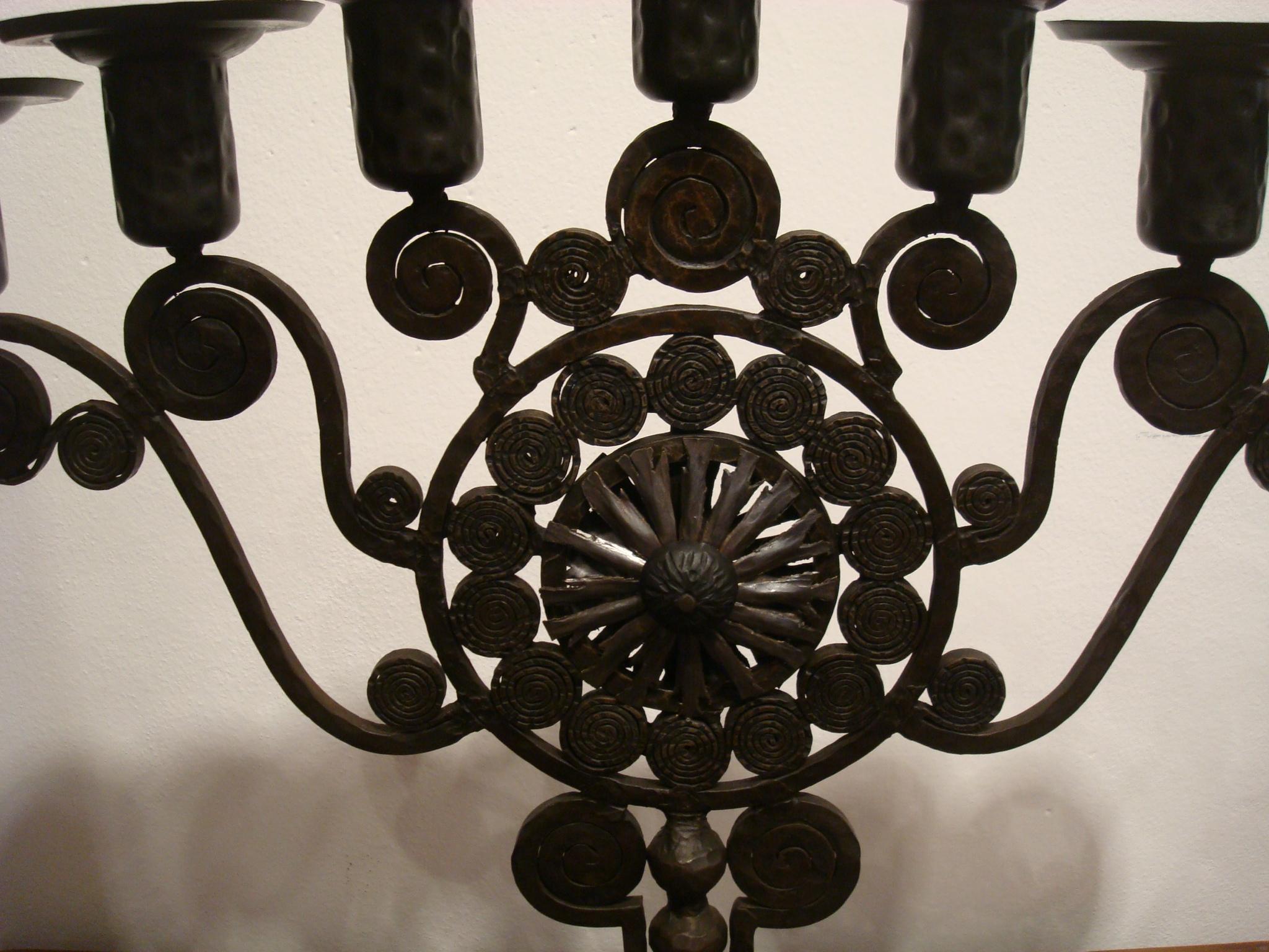 Art Deco / Secessionist period Menorah in hammered iron, with scrollwork and stylized spiral decoration, on a circular foot.
In the manner of Edgar Brandt hammered candelabra.