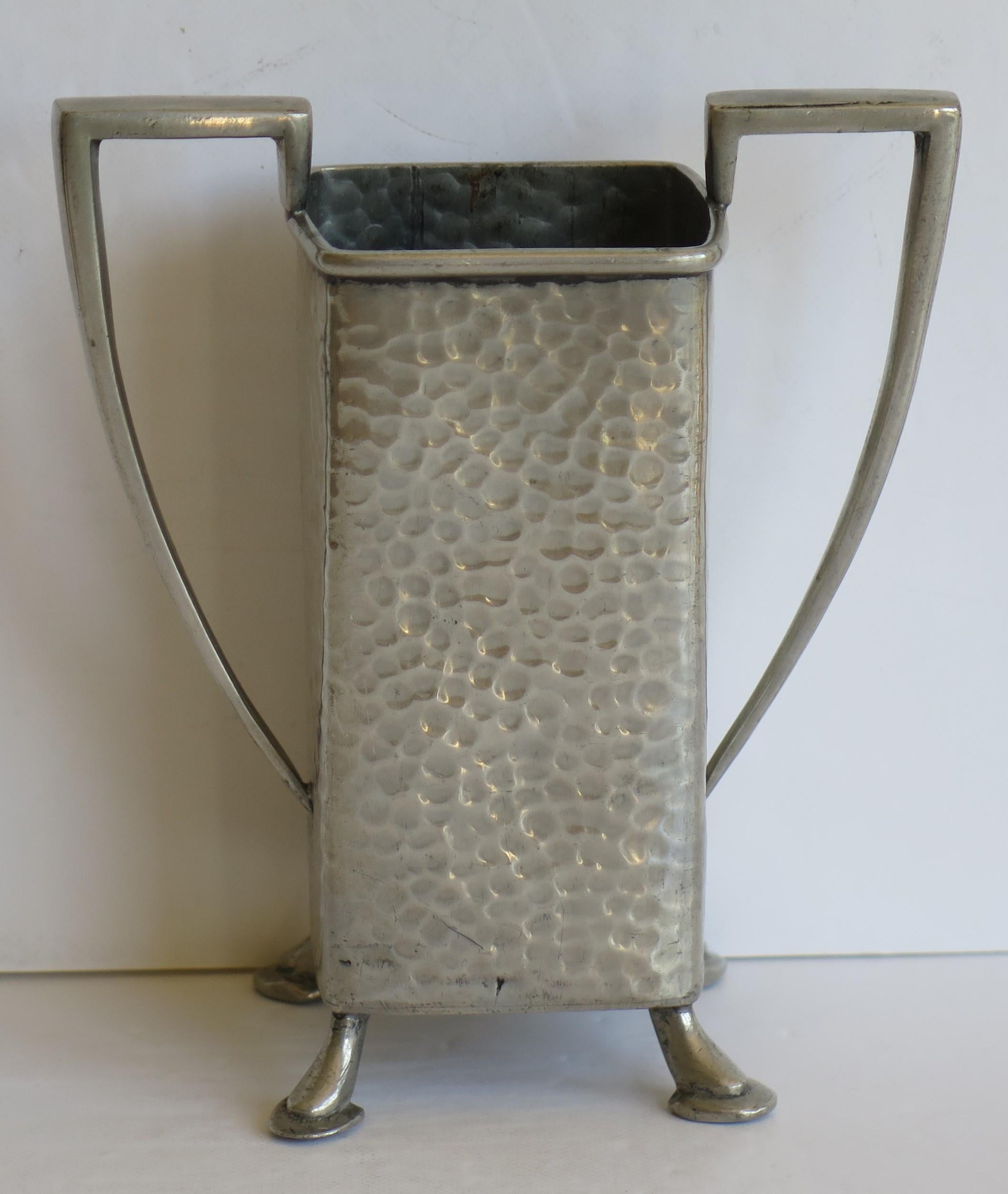 Dies ist eine sehr gute handgefertigte, gehämmerte Zinnvase von Civic Pewter, Sheffield, England, aus der Zeit des Art Deco, CIRCA 1925

Die kleine Vase hat eine schöne Form mit zwei eckigen Henkeln und steht auf vier kleinen Füßen.

Die Form