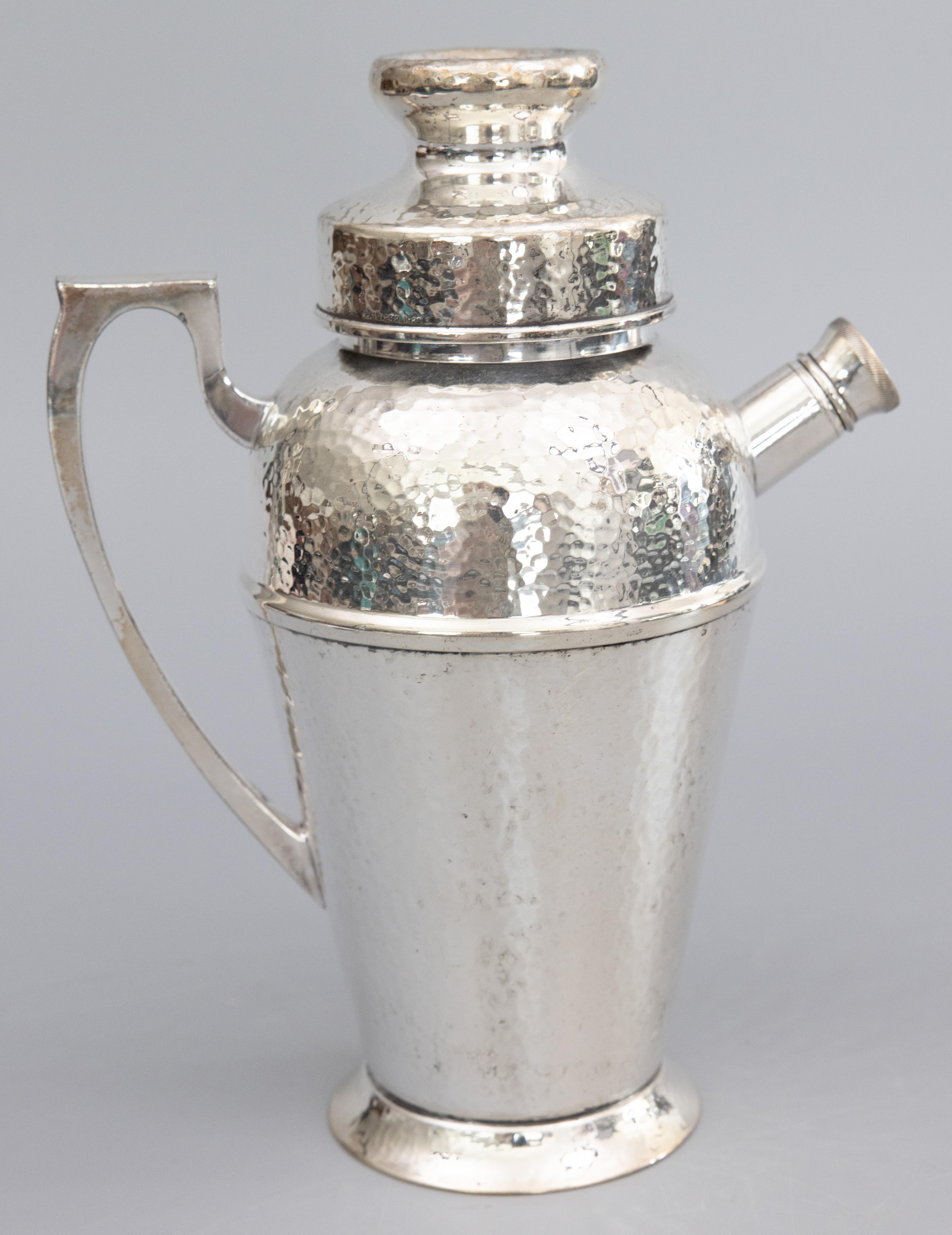 A sleek and stylish 1920s Art Deco hammered silverplate cocktail or martini shaker with removable cap and pour spout. Signed on reverse. It's decorative and functional, perfect as a gift or for your next party.

DIMENSIONS
7.5ʺW × 4.5ʺD × 9.75ʺH