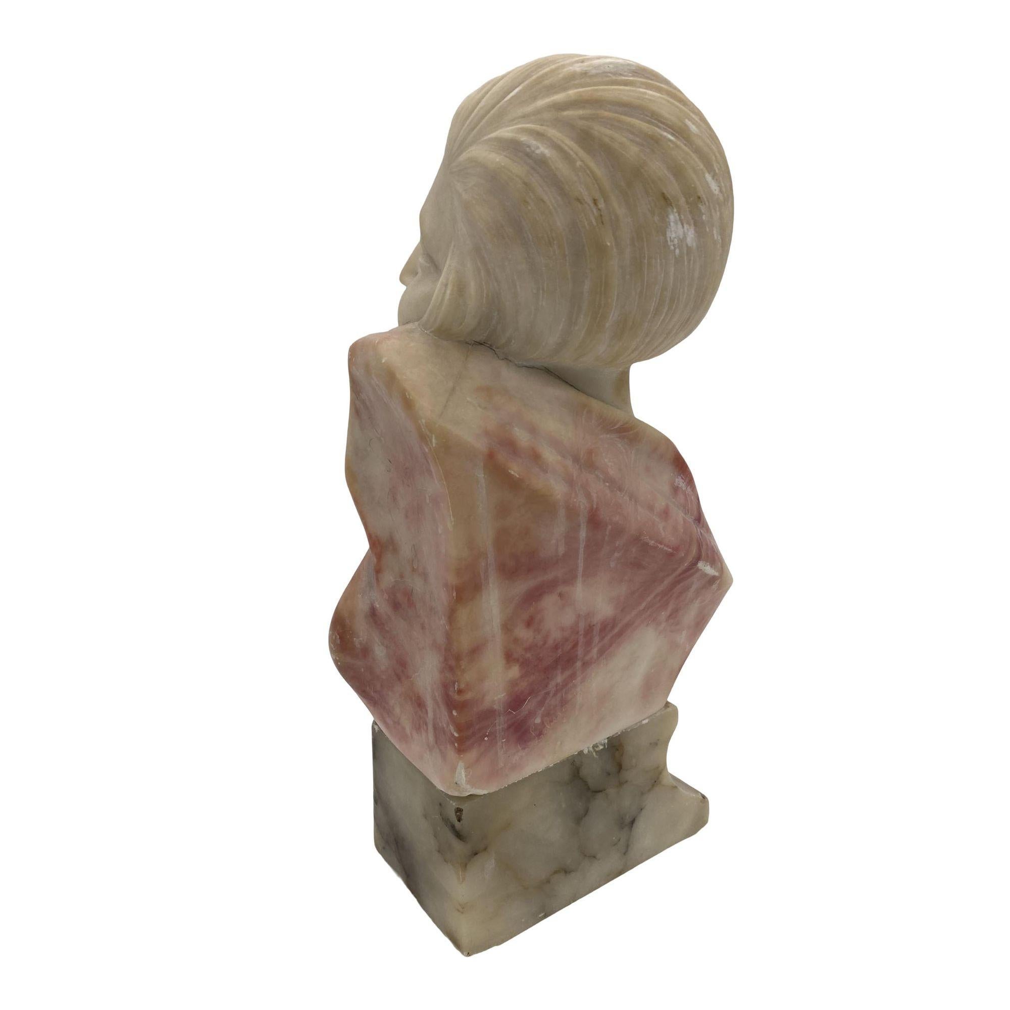 Original handgeschnitzte Art-Deco-Büste einer jungen lächelnden Flapper-Frau. Die aus feinem Alabaster gearbeitete Skulptur hat ein zweifarbiges Aussehen, wobei die Frau in weißem Alabaster und ihre Kleidung in rotem Alabaster geschnitzt ist. Die