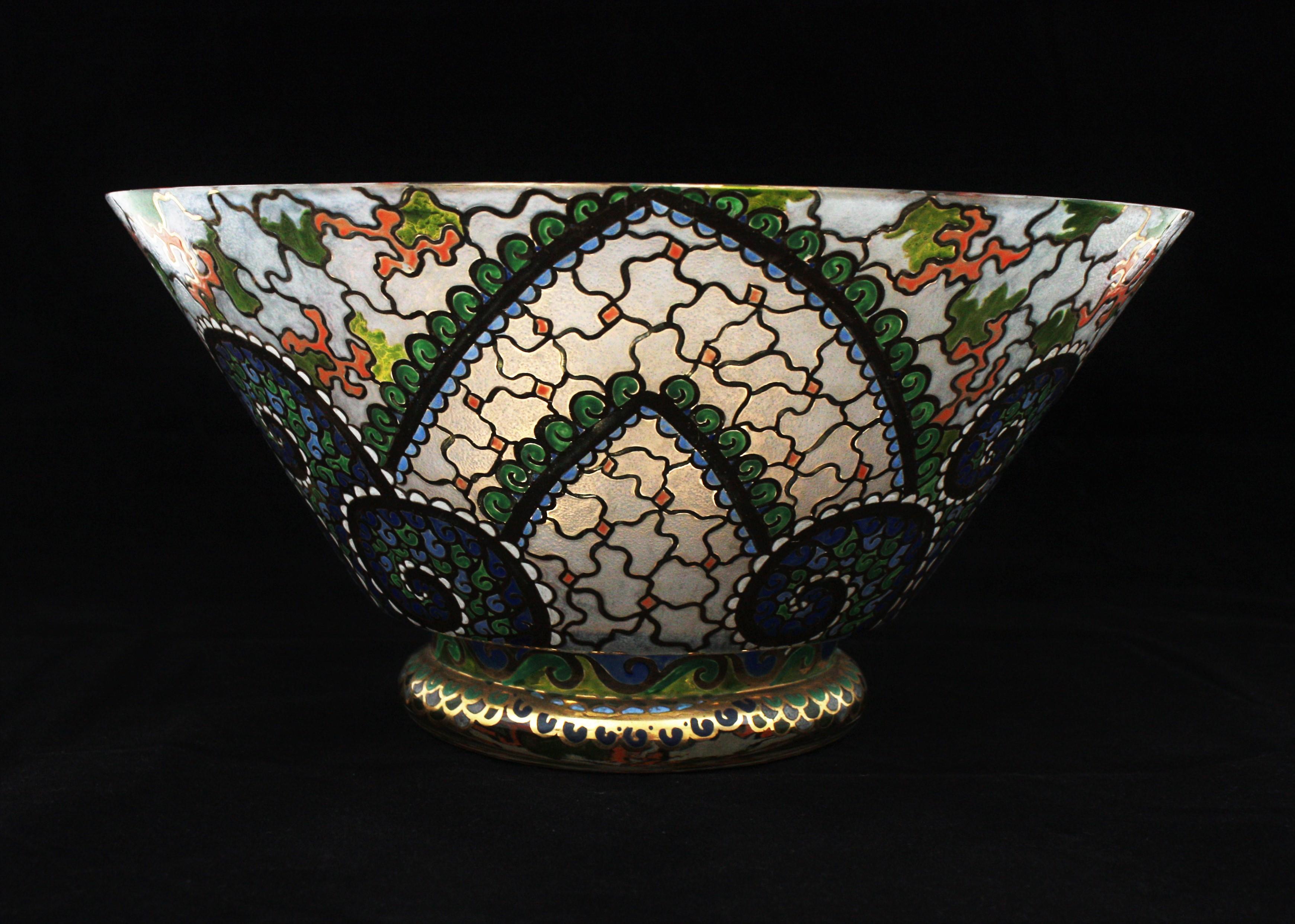 Beautiful Art Deco period hand painted blown glass centerpiece / vase by Riera, Spain, 1930s.
This colorful filigree glass decorative footed bowl has gothic inspired ornamentations in green, orange and blue colors. Exquisite hand painted enamel