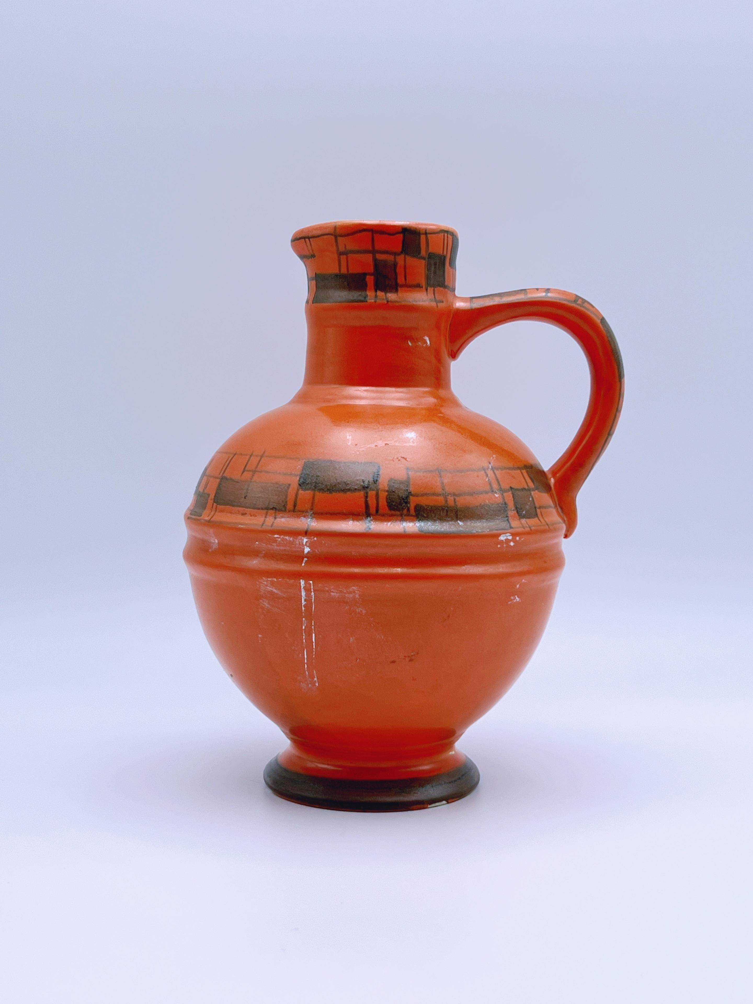Vase pichet antique de style Art Deco avec un motif peint à la main sous glaçure, présentant un design primitif scandinave/nordique. Réalisé en faïence par Egersund Faience, Norvège, vers les années 1930.

Avec sa forme élégante et ses détails