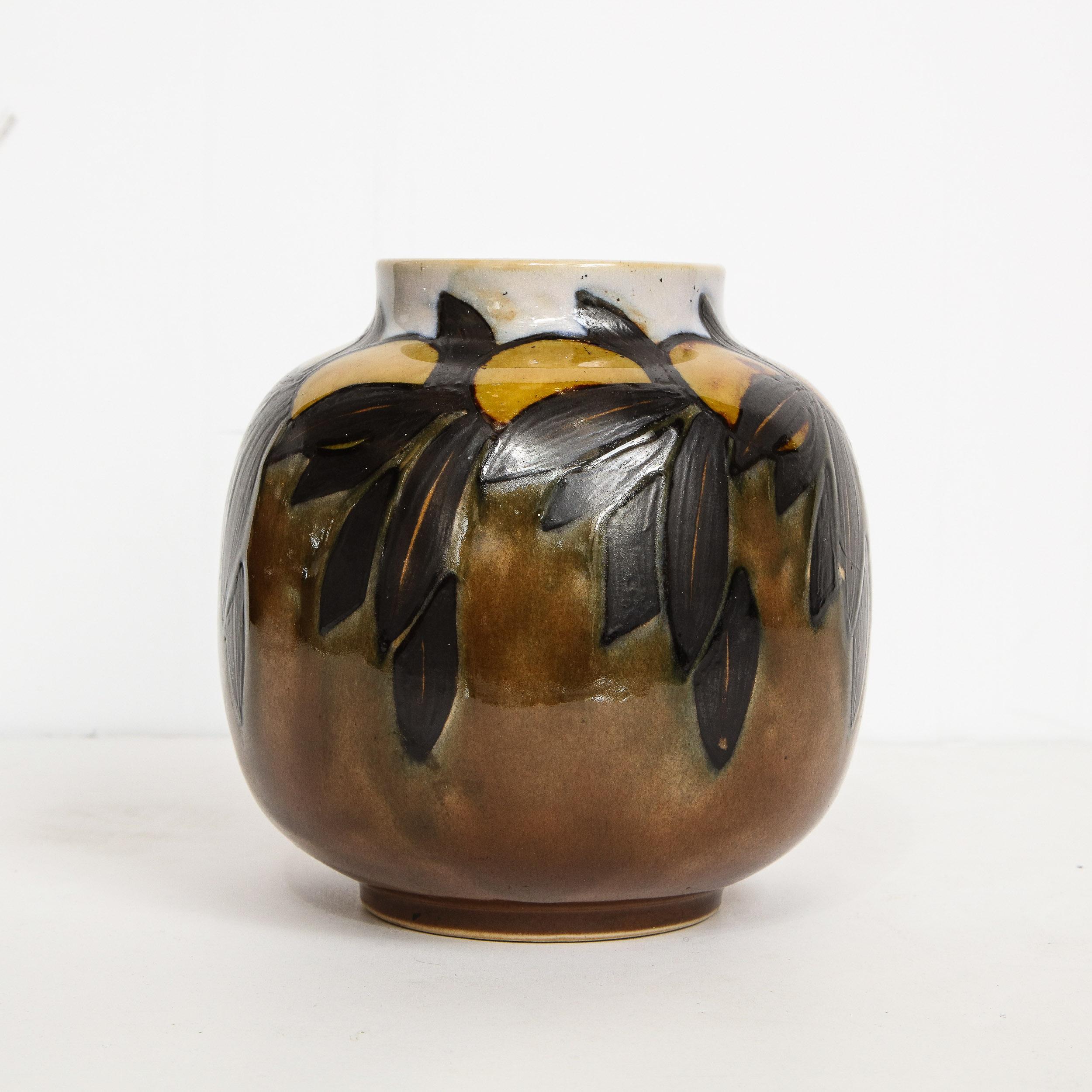 This elegant Art Deco vase was realized by the esteemed British Studio of Royal Doulton, circa 1930. It features a rounded form with a circular neck in glazed ceramic. The piece has been hand painted with a stylized fruit, apparently peaches or