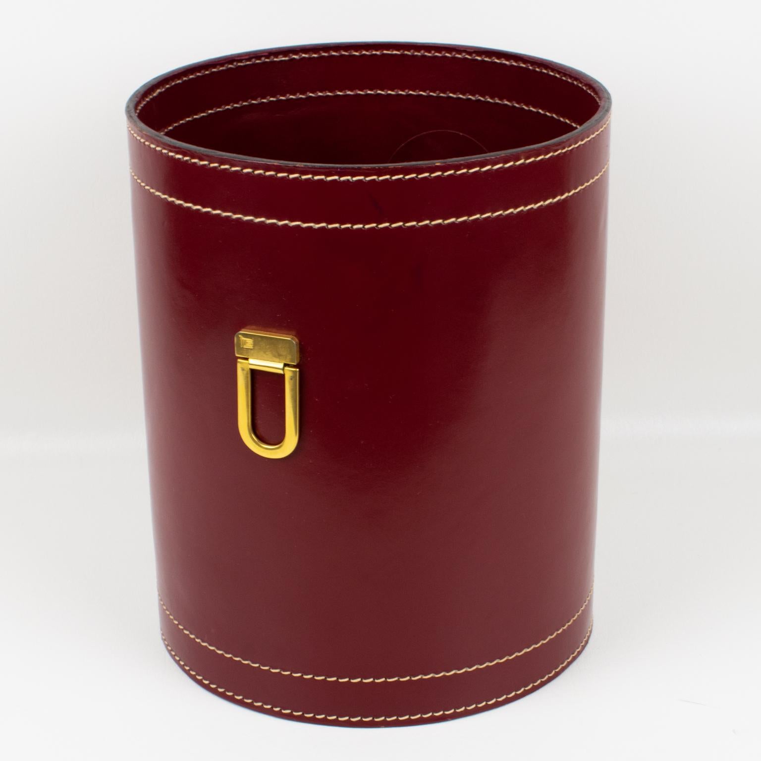 A functional 1940s modernist desk accessory, office waste-basket designed by ILG, Belgium. Streamline shape with burgundy red hand-stitched leather and gilded brass handles on the side. All leather inside and out. A very nice addition to your next