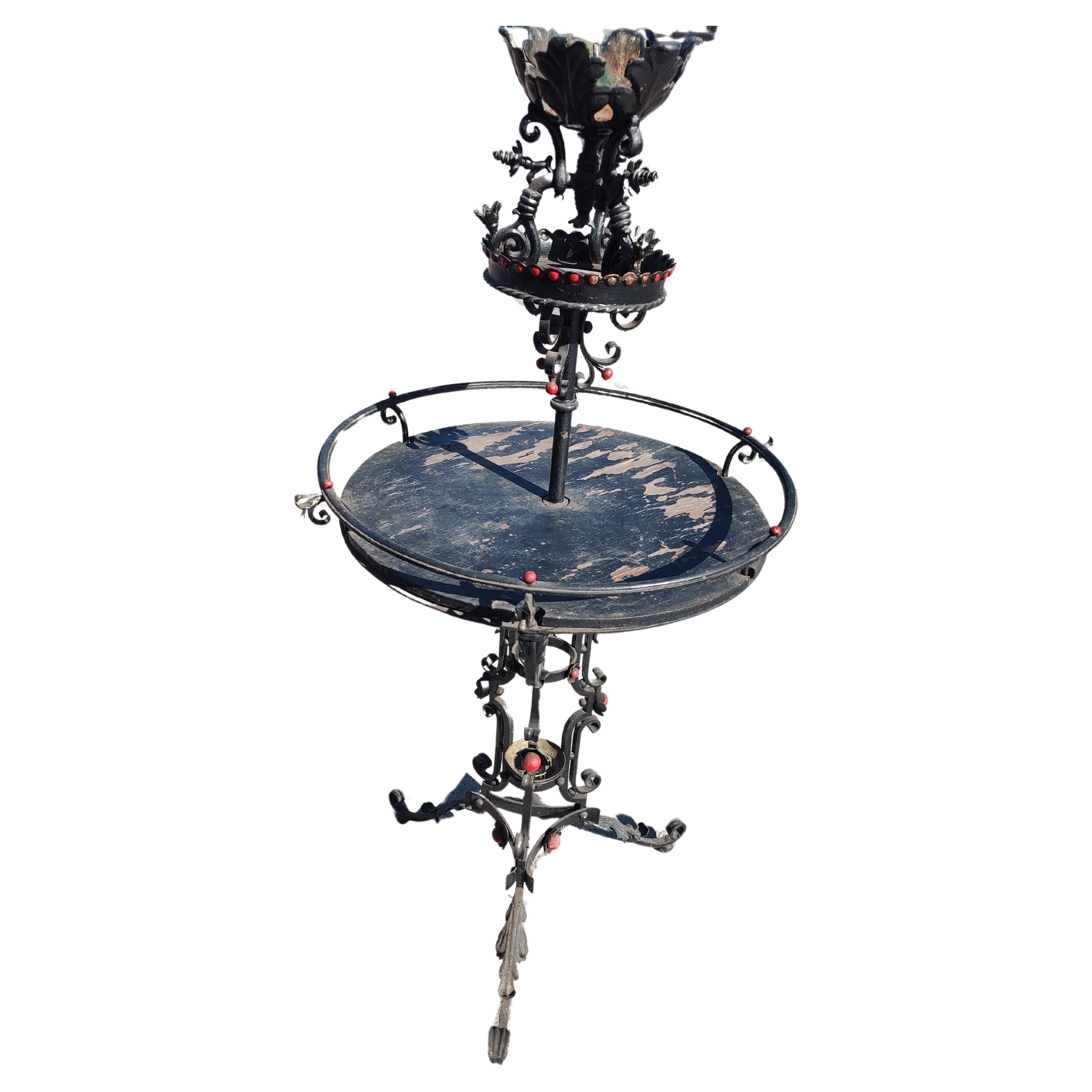 Fantastic large and ornate iron work in the style of Oscar Bach. A very decorative piece designed to hold many potted plants. A large round central element which is supported by an iron frame and a piece of hardwood which would support many potted