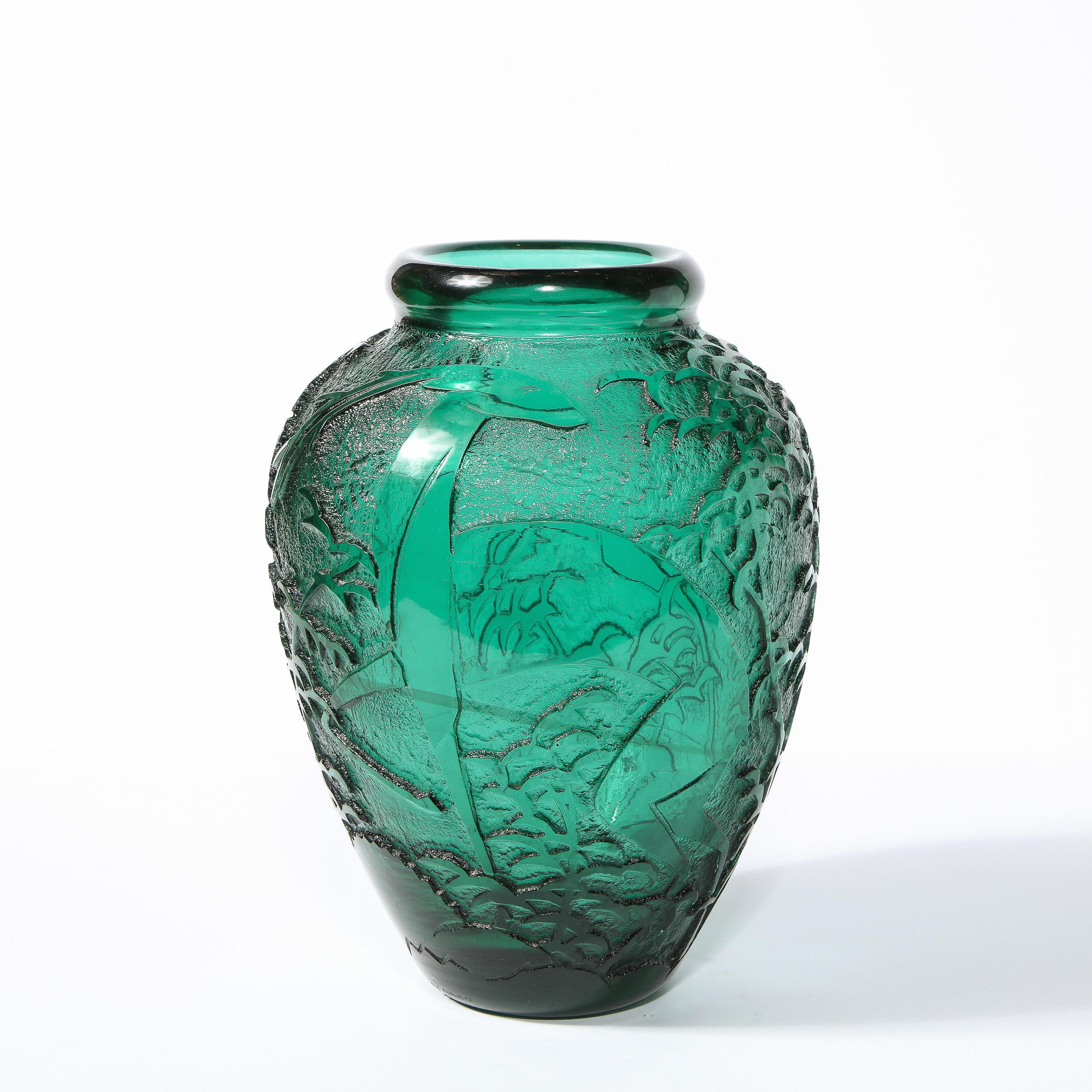 This refined Art Deco vase was realized and signed Nancy Daum in France circa 1925. It features a conical body in molded teal glass with a rounded shoulders and a raised circular mouth. Stylized ibis and repeating cloud motifs appear etched