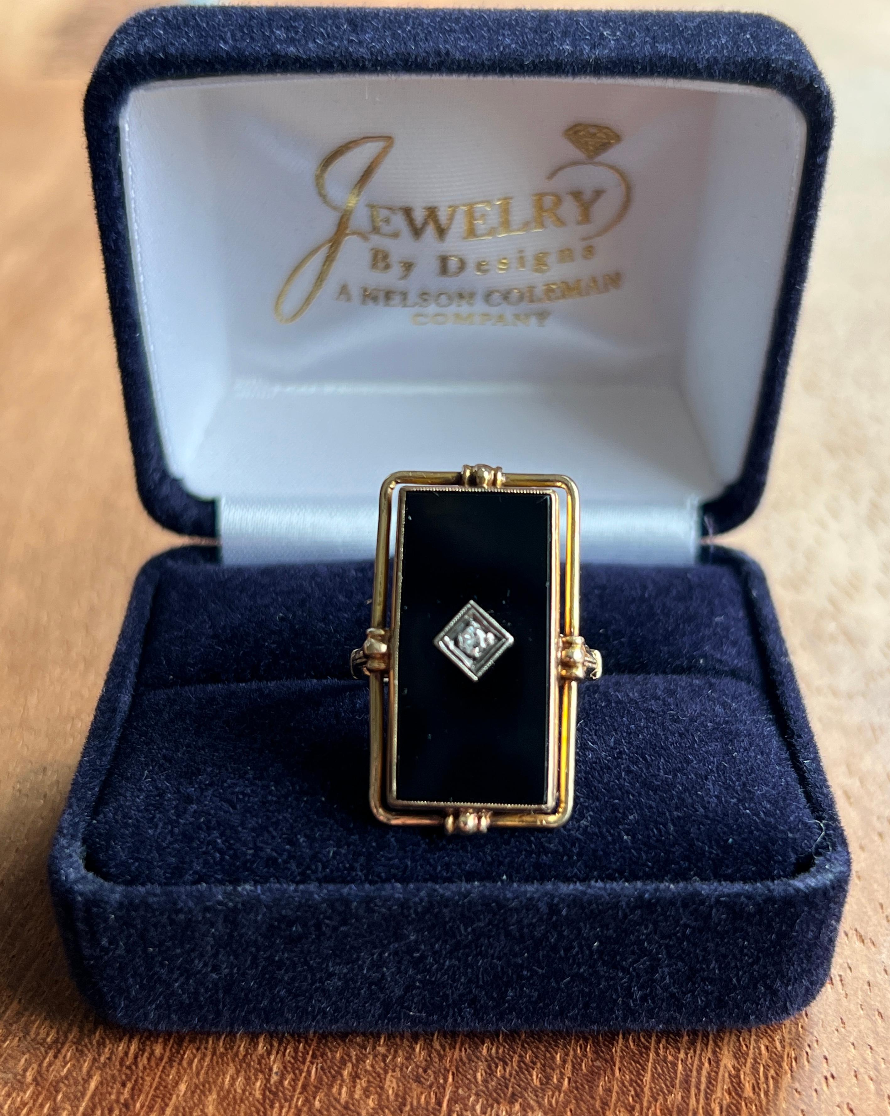 A striking example of 1930s Art Deco elegance, this handmade ring features bold geometric lines and a rich contrast of textures and tones. Crafted in 10 karat yellow gold and stamped both “10K” and “HANDMADE,” the ring is centered with a rectangular