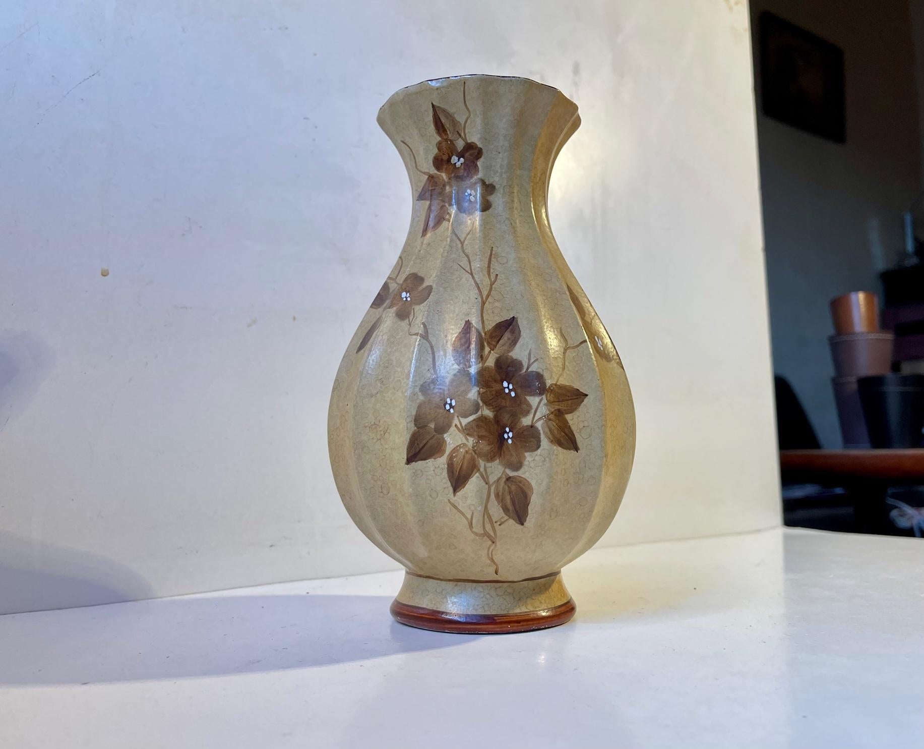 A classic Art Deco shape vase fully glazed in earthy tones and decorated with handprinted flowers. Designed and manufactured by Knabstrup in Denmark during the 1920s or 1930s. Measurements: H: 22 cm, D: 12 cm at the center.