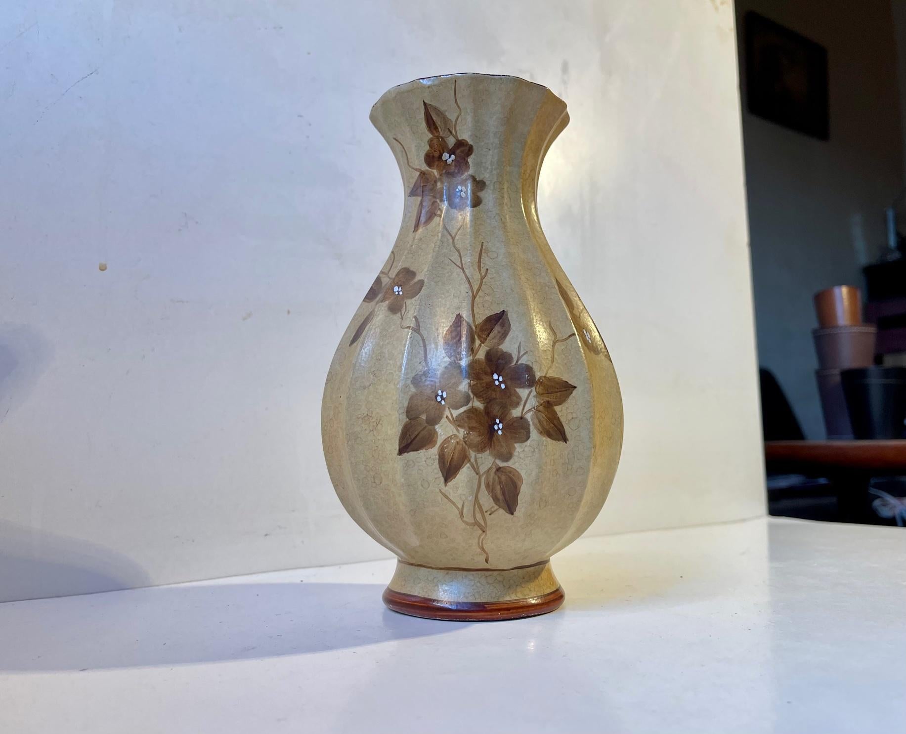 Un vaso dalla classica forma Art Decor completamente smaltato nei toni della terra e decorato con fiori stampati a mano. Progettato e prodotto da Knabstrup in Danimarca negli anni Venti o Trenta. Misure: H: 22 cm, P: 12 cm al centro.