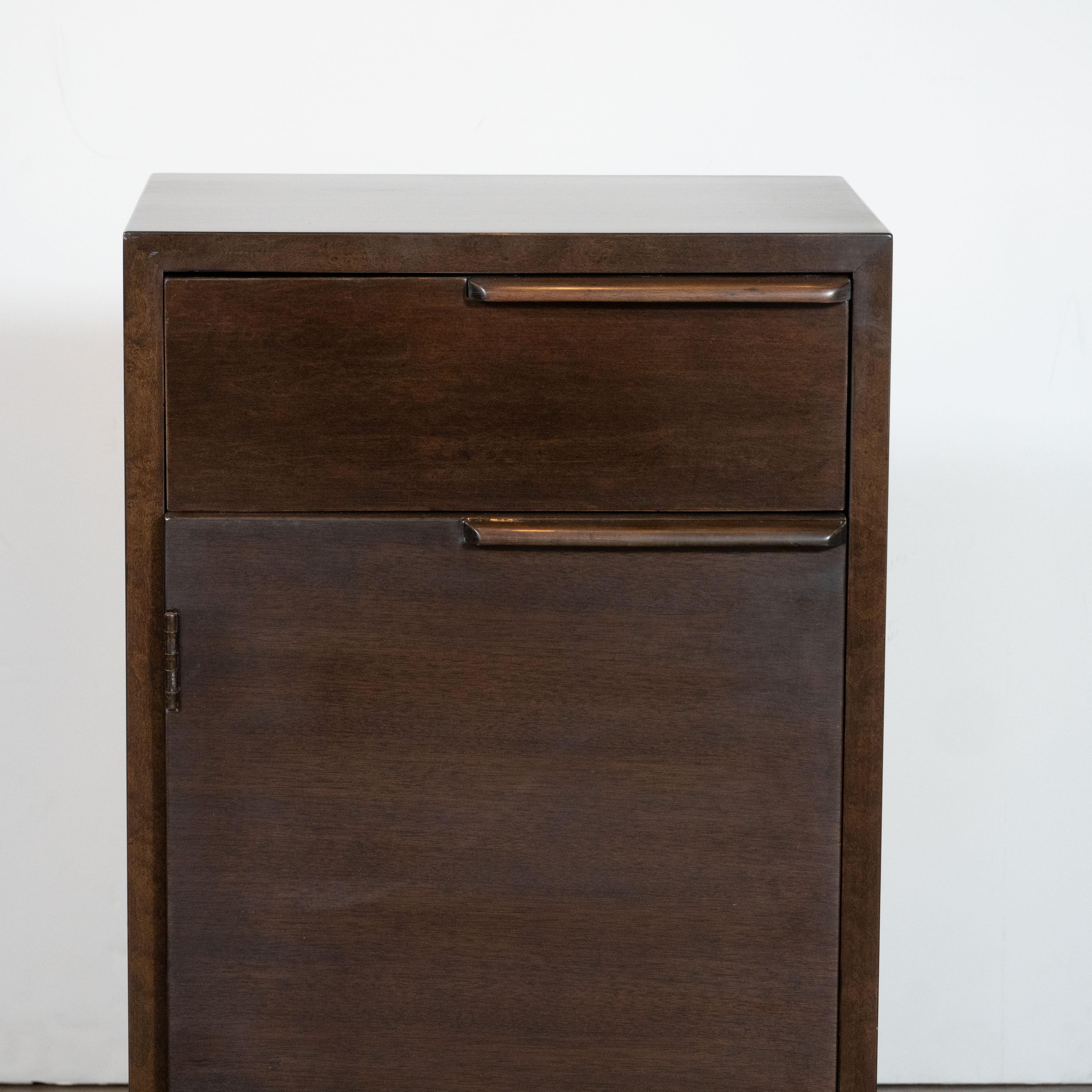This elegant and understated nightstand was realized by Gilbert Rohde, one of the most celebrated and influential designers of the 20th century in the United States- in 1936. Handcrafted in Zeeland, Michigan, the piece features a volumetric