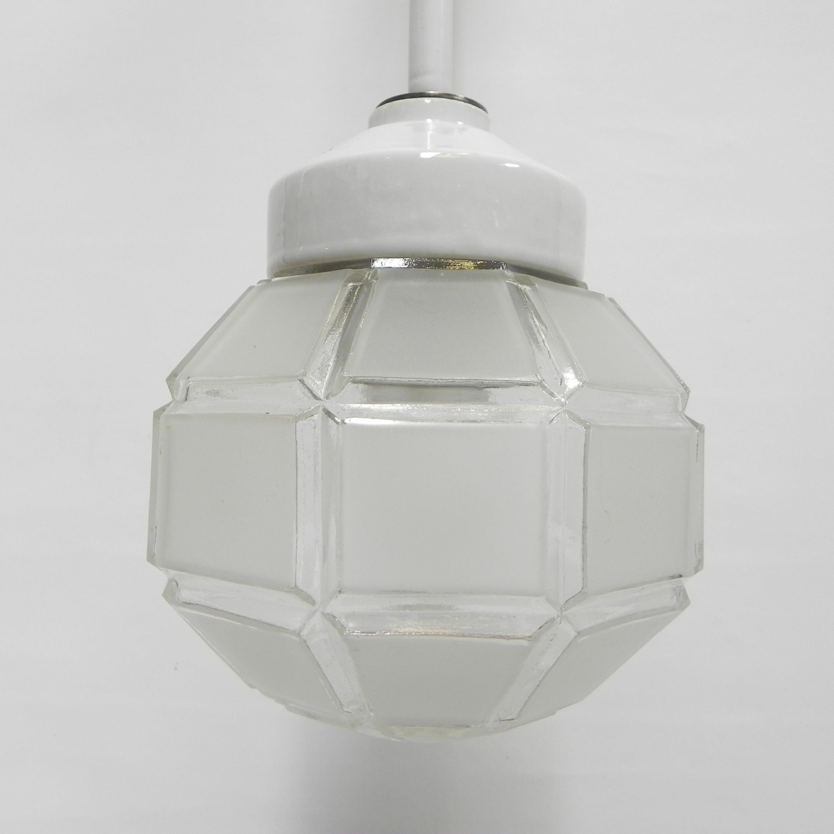 This hanging lamp has a porcelain shade holder at the bottom
and a porcelain ceiling cover at the top.
Connected by an enamelled steel rod.
The frosted glass shade is screwed into the porcelain shade holder.

Total length: 68 cm.
Ø glass shade: 17