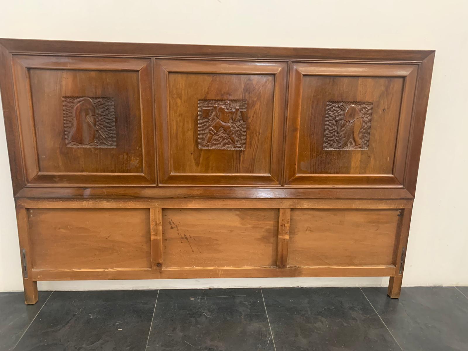 Headboard part of a bed of great quality solid walnut it presents 3 panels carved with futuristic characters on a gouged background. The design, the type of carving reconnect the type of Marelli and Colico. 
The footboard is not available, there