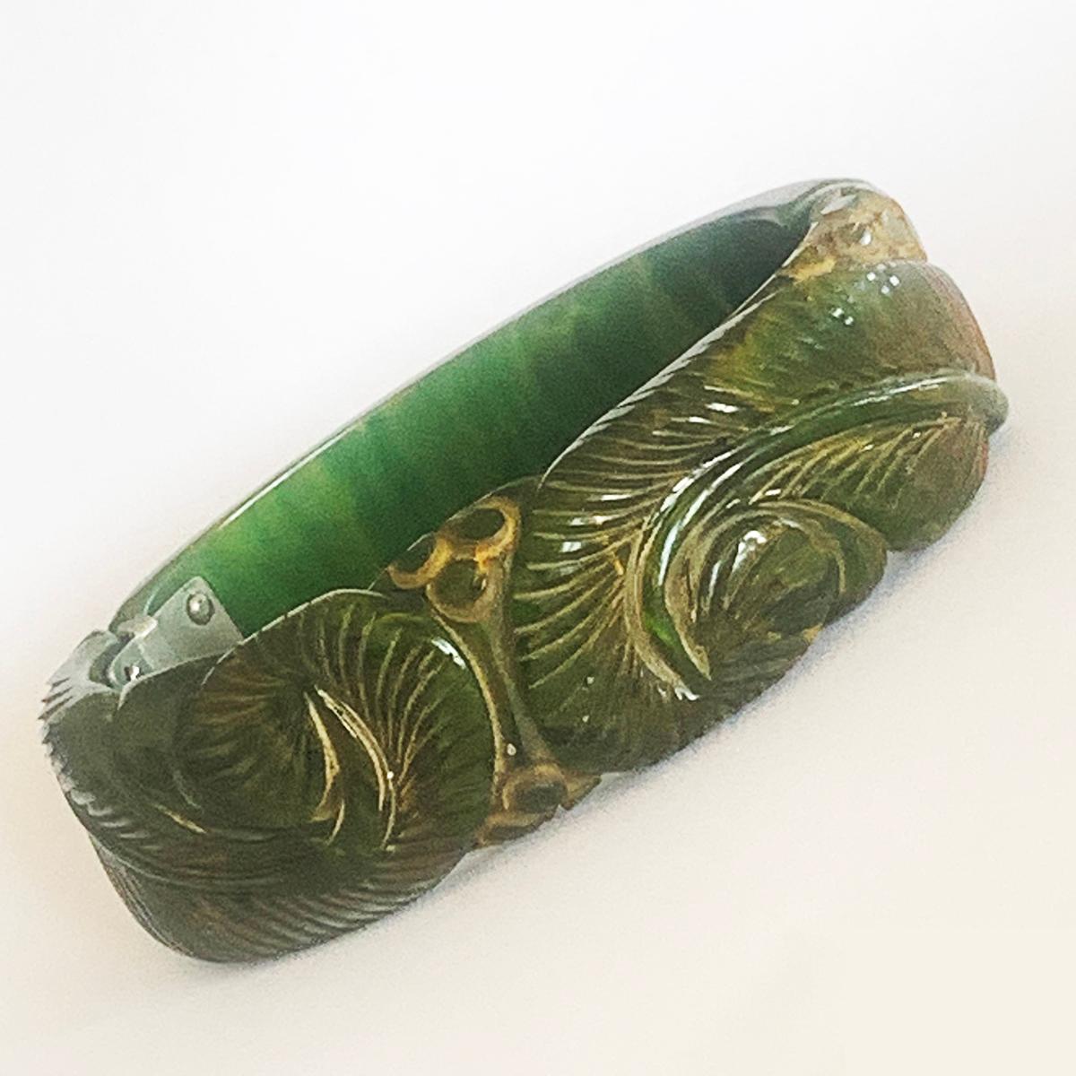 Art Deco Green Bakelite with fine yellow veins, Clamper Bangle, deeply Carved in form of Fern Fronds and Berries, and softly stained with a yellow/orange patina to the engraved details. All in excellent condition, including the springs and nickel