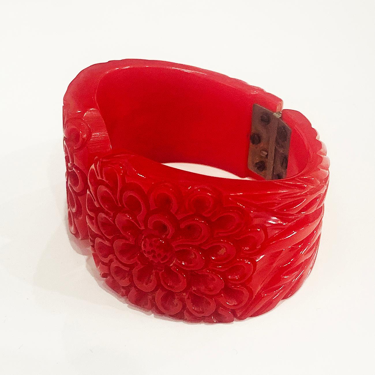 Art Deco Clamper Bangle heavily and intricately carved in form of a Chrysanthemum flower, Brilliant Lipstick Red. Original nickel plate spring hinge in perfect working condition, with no damage or repairs at all to the bangle. One of the best you