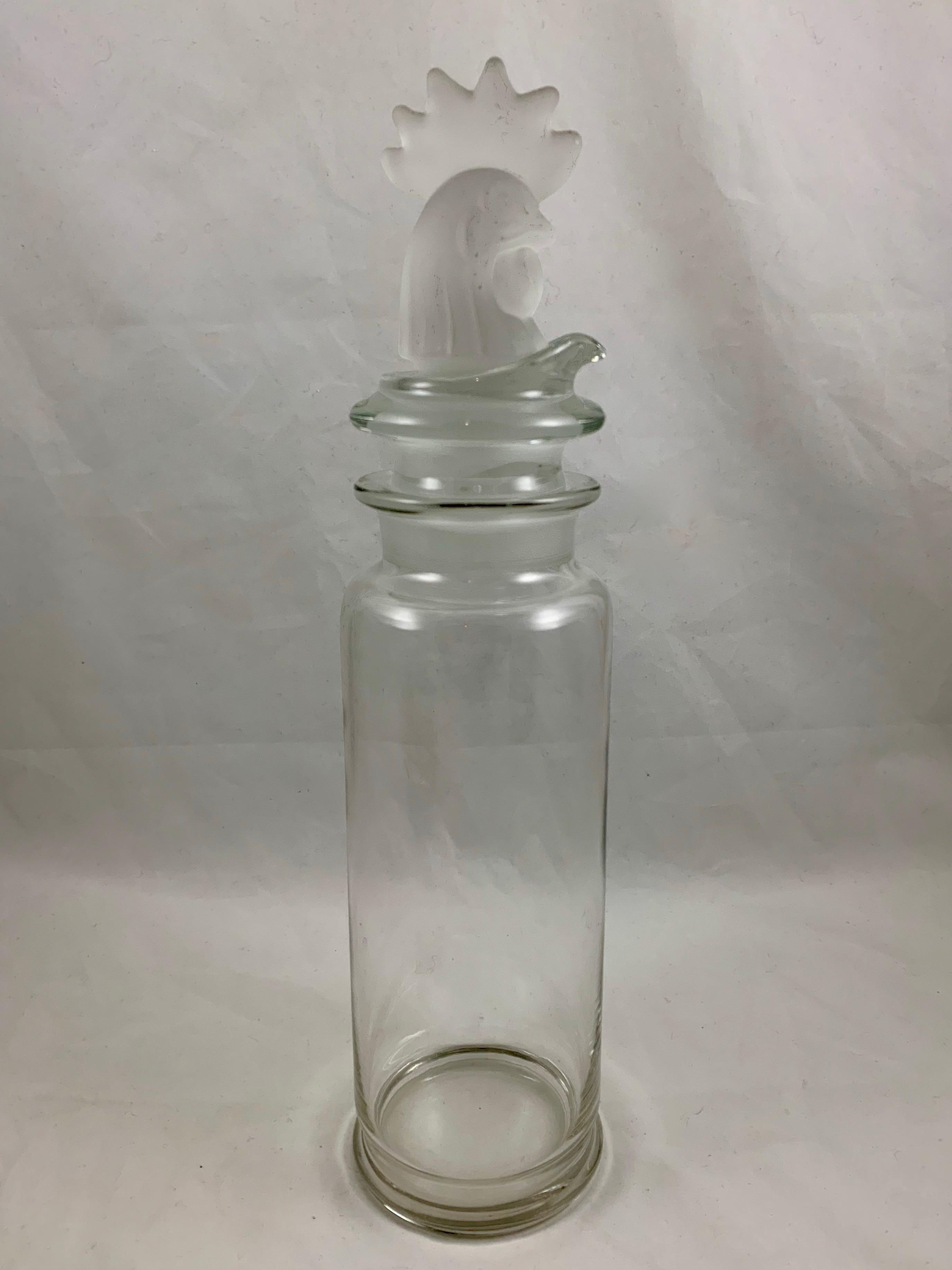 An Art Deco period, Heisey glass, tall three-piece cocktail shaker with a frosted Rooster head stopper, circa early 20th century. 

The neck of the shaker holds an inset pourer formed with a strainer which then holds the stopper. All three pieces