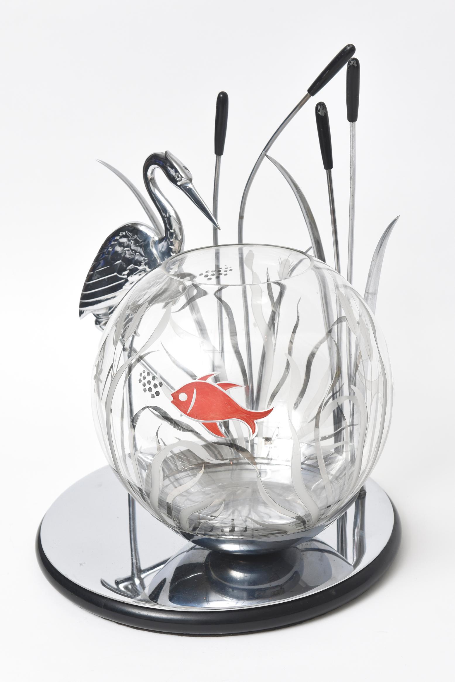 Rare Art Deco piece featuring a crane or heron walking amongst a group of cattails while watching fish in the water. The bowl is decorated with an etched frosted glass scene which is accented with a painted silver and red scene. The bowl features 3