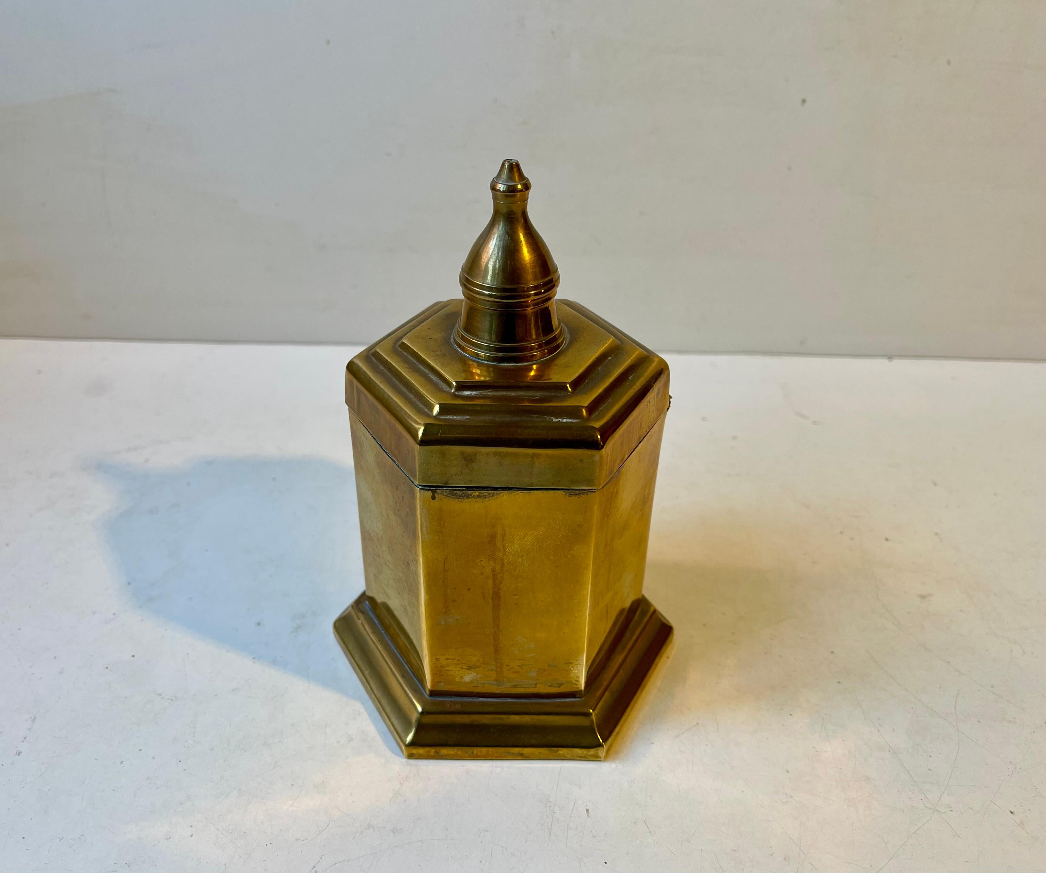 Hexagonal tea caddy - canister in solid brass. Probably made in England during the 1920s or 30s. Art Deco styling particular to the architecturally perceived 'staired' design on the lid. It display a rich and beautiful patina consistent with its