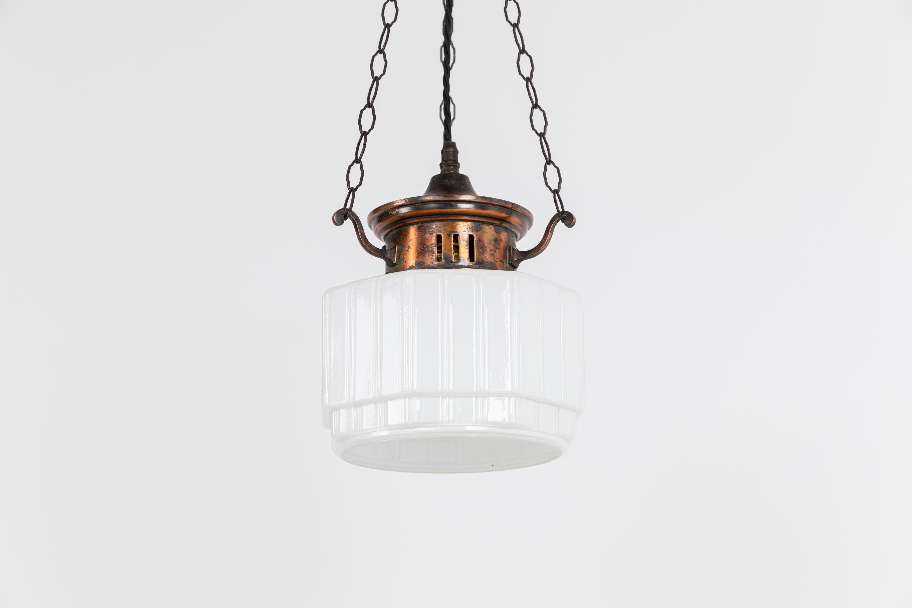 A diminutive and elgantly formed opaline pendant lamp with copper gallery. c.1920.

Thick pressed glass of ridged hexagonal form with open bottom, complete with copper gallery supported by three extended hooks and ornate ballhook. Ceiling hook also