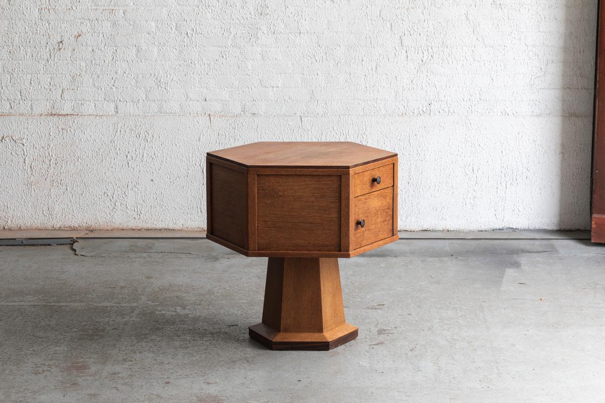 Side table, designed and produced in the Netherlands around 1930. This oak cabinet with two drawers and two small doors in a hexagonal shape can be a conversation starter in any interior. Overall in good condition with a few scratches,