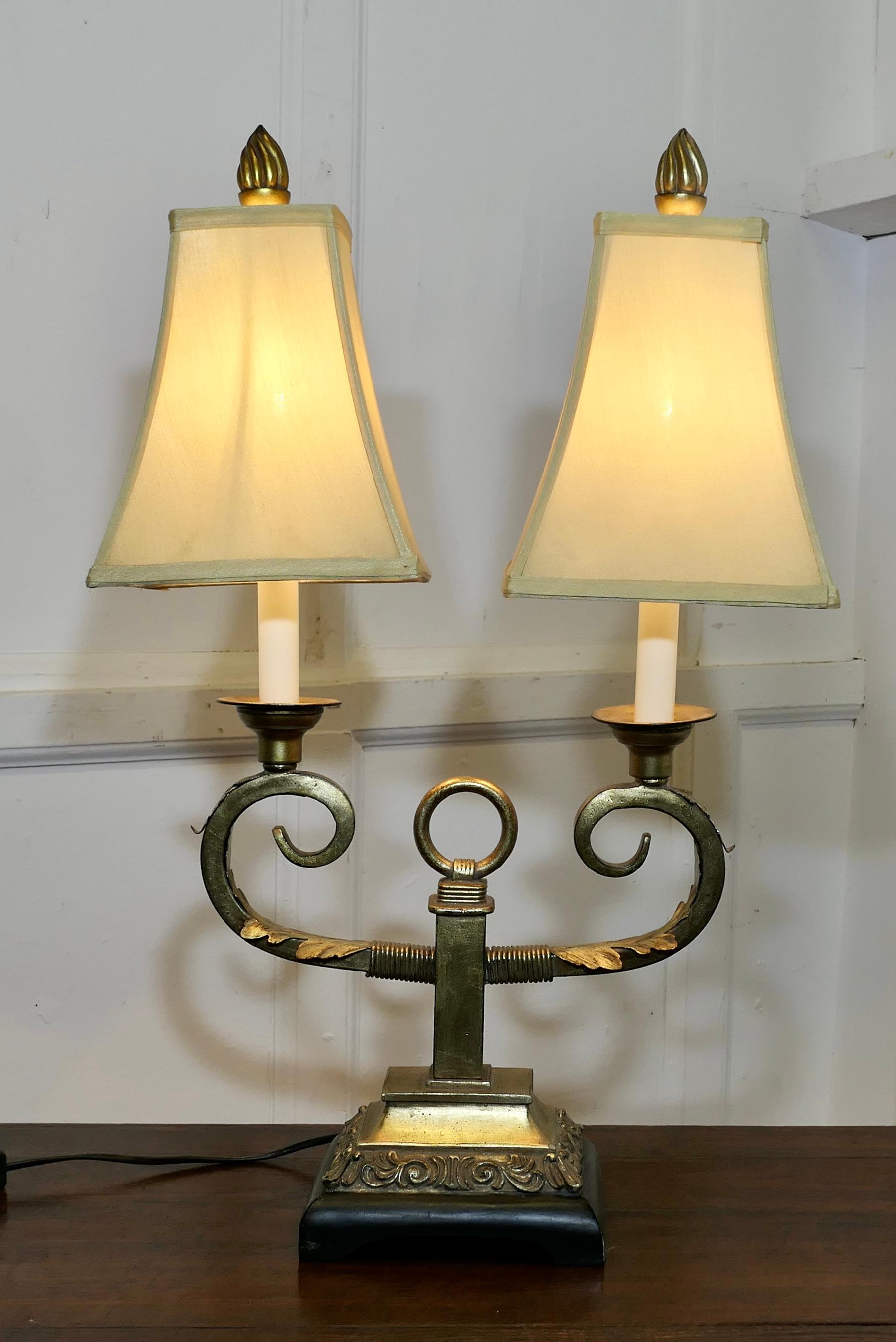Art Deco Hollywood Regency Twin Toleware Table Lamp

This is a charming piece, it is made in brass and toleware, it has 2 large curled branches each topped with a large lampshade
All in good working condition with an age related patina

The lamp is