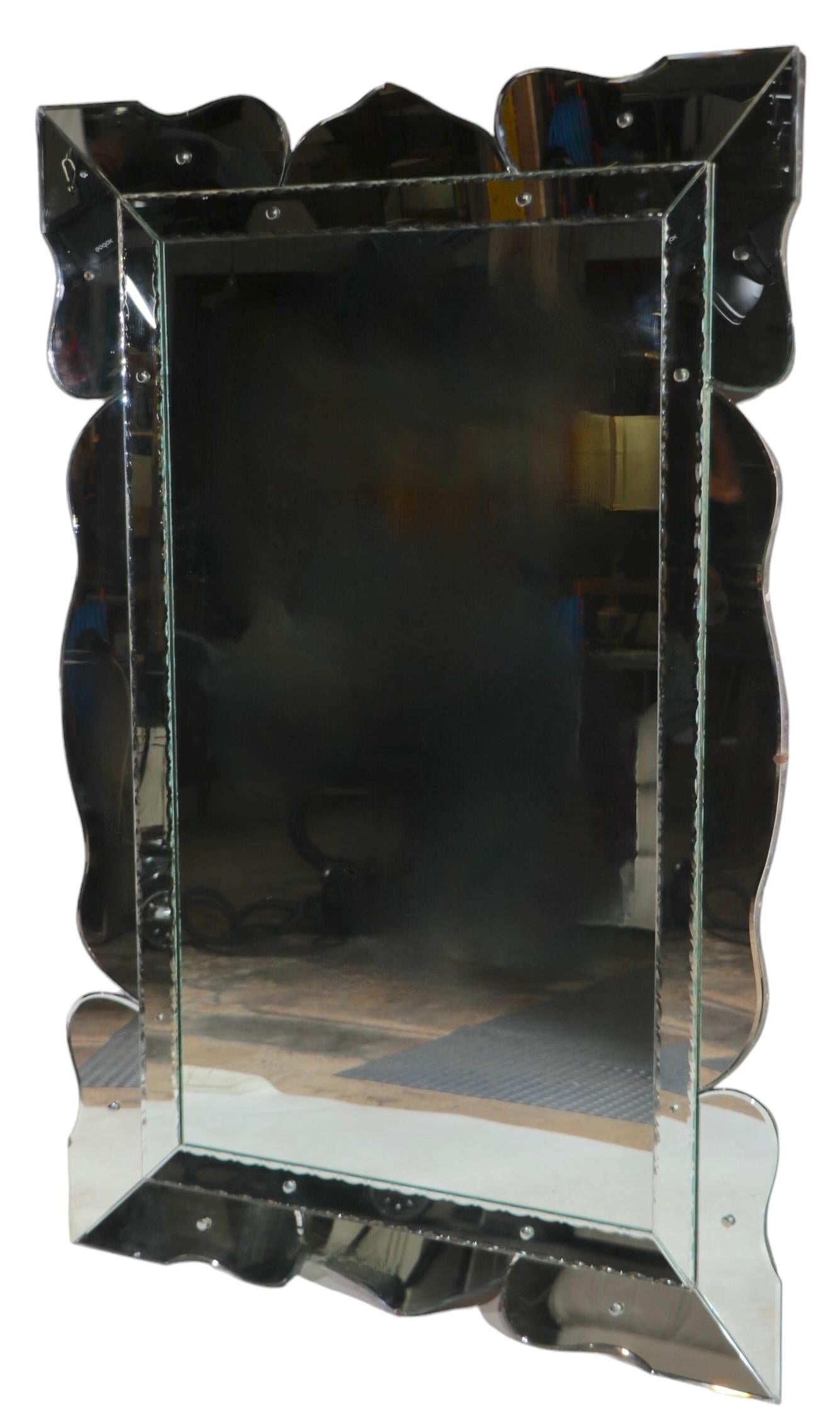 Exceptional Venetian style Art Deco, Hollywood Regency wall mirror, in very fine, original, ready to install condition. The mirror features a  picture frame style border, which surrounds the large rectangular center panel. This impressive example