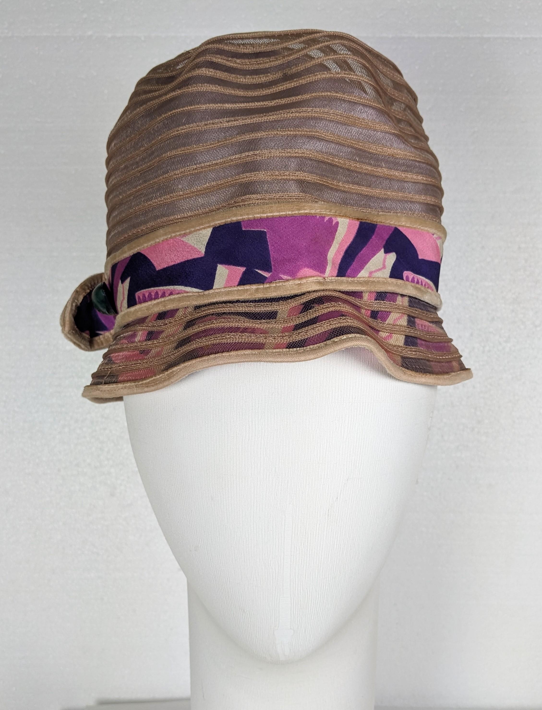 Art Deco cloche hat composed of horizontal bands of light mauve horsehair with an Art Deco printed band of crepe de chine. 1920's USA. Original bakelite hat pin.
Brim 1,5 