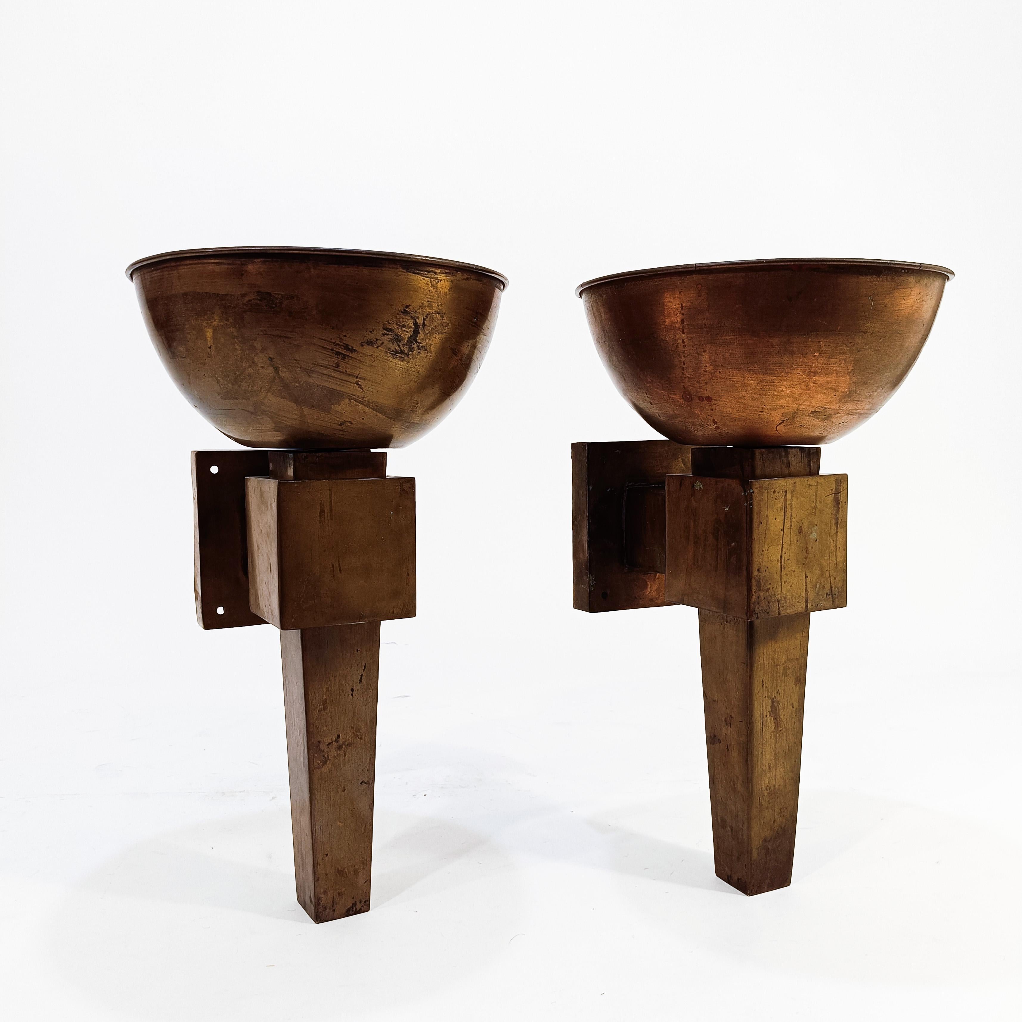 Zwei große Wandleuchter im Art-déco-Stil, um 1925. Ganz aus Messing/Kupfer in Form einer Fackel, die an ägyptische und römische Fackeln erinnert, zwei alte Kulturen, die im Art déco-Stil weit verbreitet sind. Beide Lampen bestehen aus zwei Teilen: