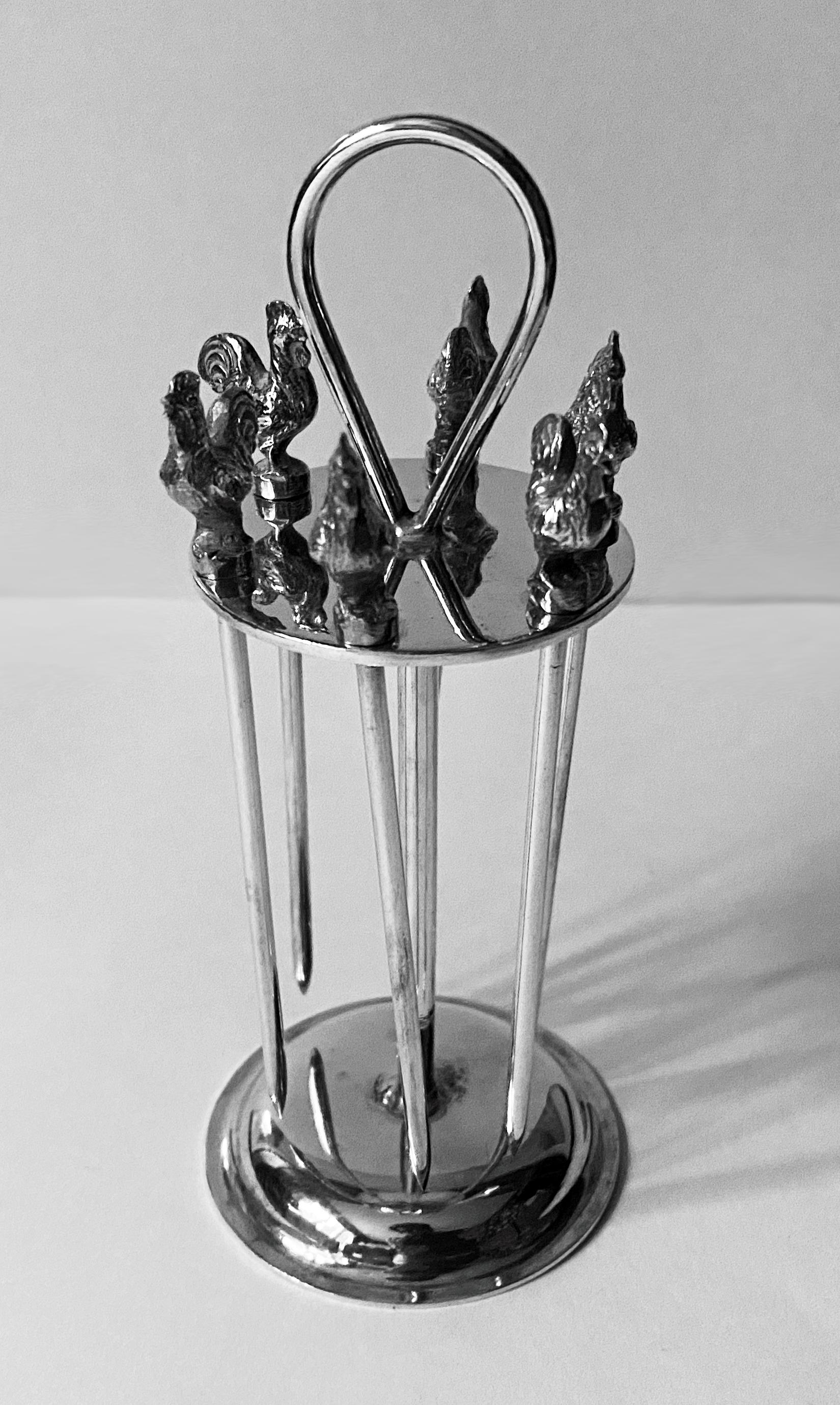 Art Deco Hukin and Heath silver plate cocktail set, circa 1930. Upright form with holders for six rooster head cocktail sticks. Measures: Height: 5.25 inches, diameter: 2 inches.