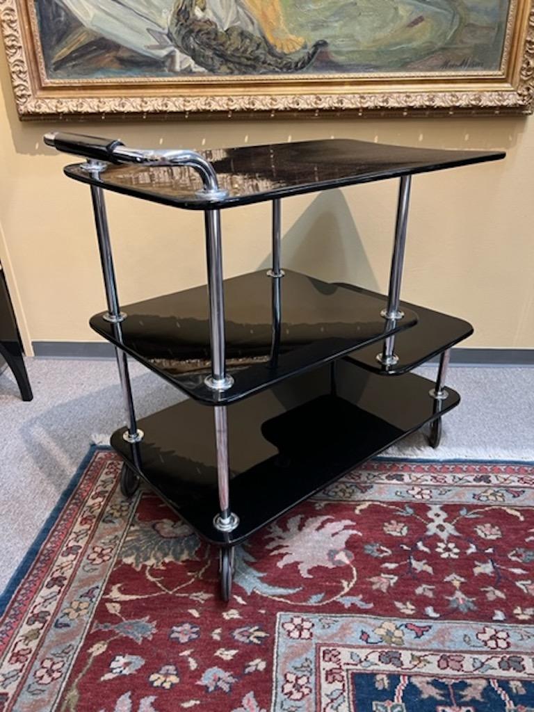 Bar cart has very unique design. It composed out of 4 wood ebonized shelves for storing different size items. They connected by 4 chrome tubes that support the whole bar cart structure. There is a wood/chrome handle and 4 wheels for easier