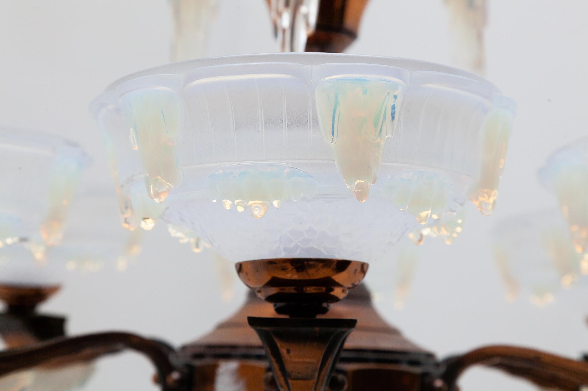 Large molded opalescent frosted art glass, six-arm chandelier by Ezan Petiot, France, 1930s. Smokey brass frame with decorative milk glass drops formed like snow caps or icicles.
In overall excellent condition, dimensions: 80 diameter x 85 height