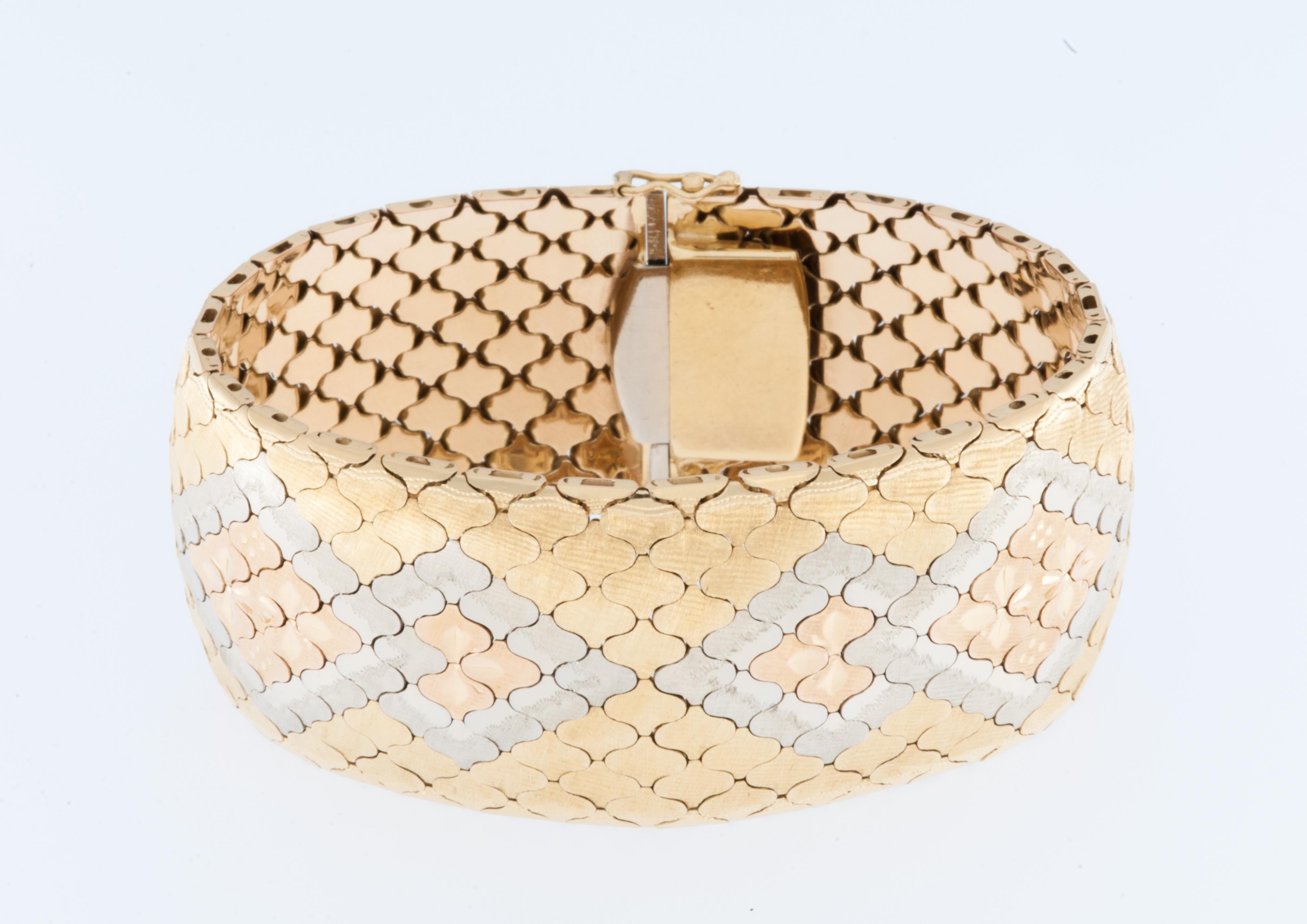 Das Art Deco Iconic Cuff-Bracelet ist ein atemberaubendes Stück, das mit Präzision und Eleganz gefertigt wurde. Diese Manschette aus 18 Karat Gelb-, Weiß- und Roségold strahlt Luxus und Raffinesse aus. Das Wabendesign sorgt für einen Hauch von