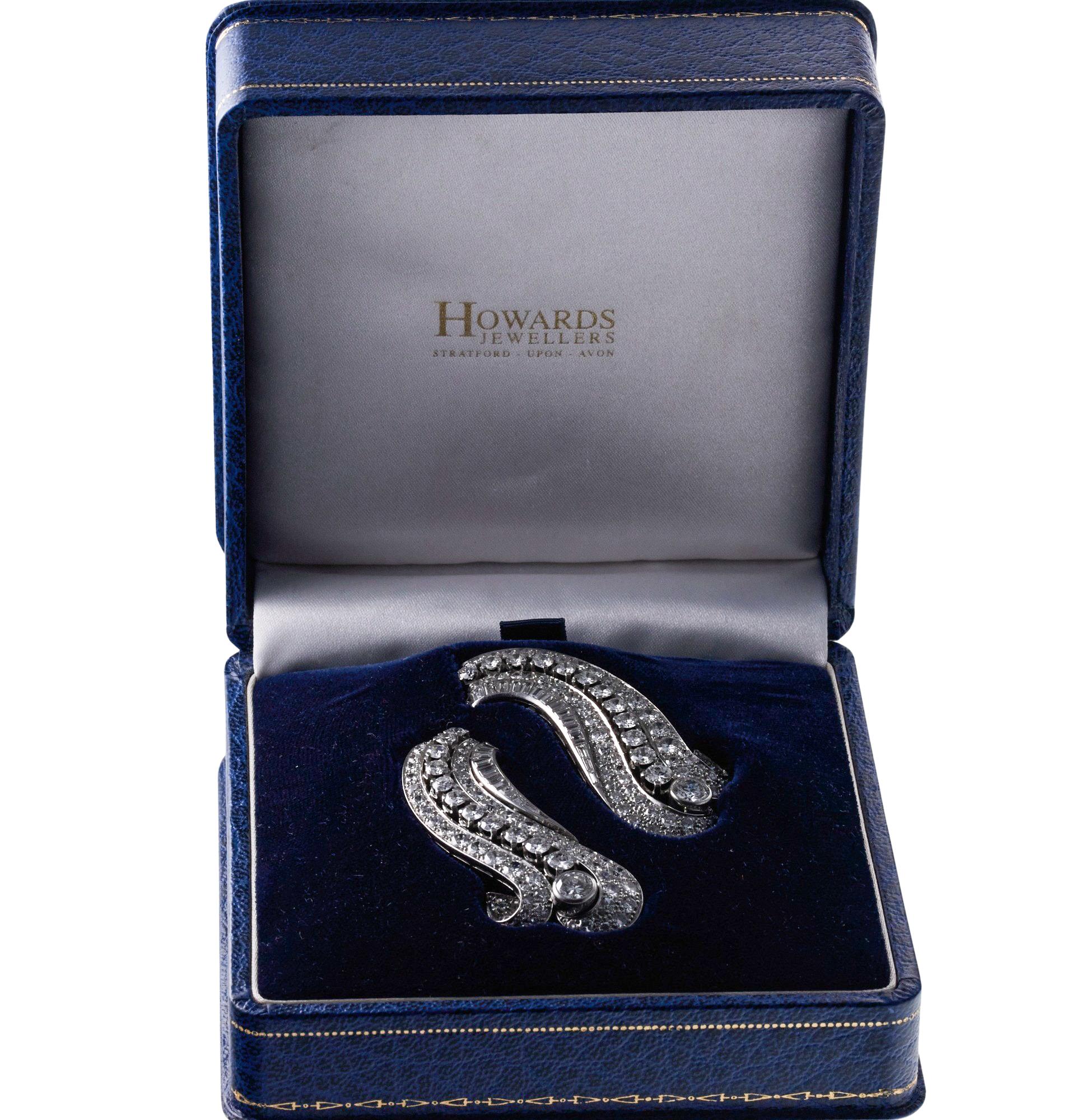 Pair of exquisite iconic Art Deco brooches, set in platinum, each adorned with a approx. 7 carats in H/VS-Si diamonds. Total approx. 18 carats. Set comes in original fitted box from the retailer Howard Jewelers. Each brooch measures 2.25