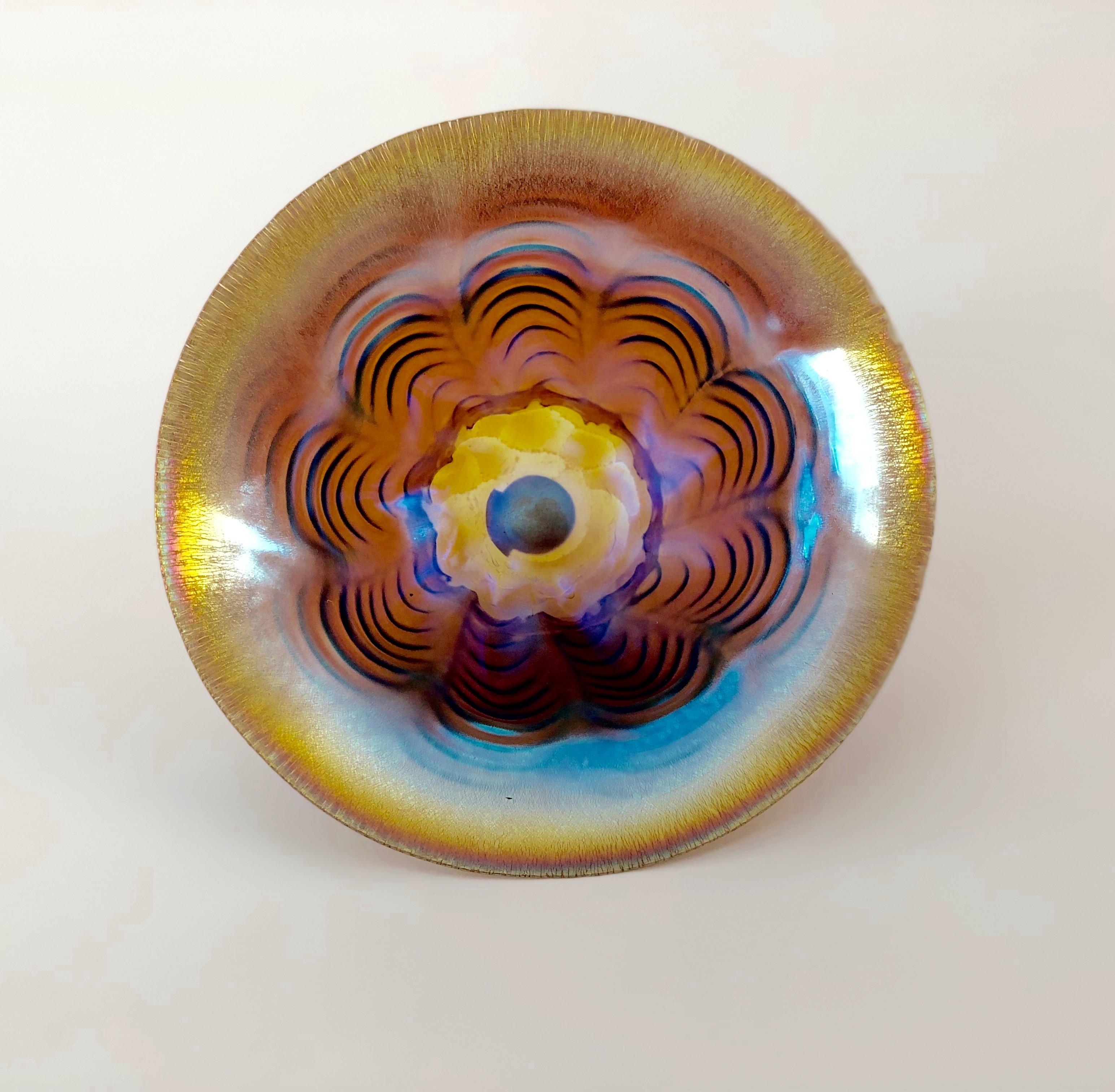 Kleine Art Deco Glasschale aus der Manufaktur WMF, Deutschland. Diese Schale gehört zu der Technik Ikora, die vom Hersteller in den frühen 1920er Jahren patentiert wurde. Mit dieser Technik wird transparentes Glas irisierend gemacht.
Auf dem Boden