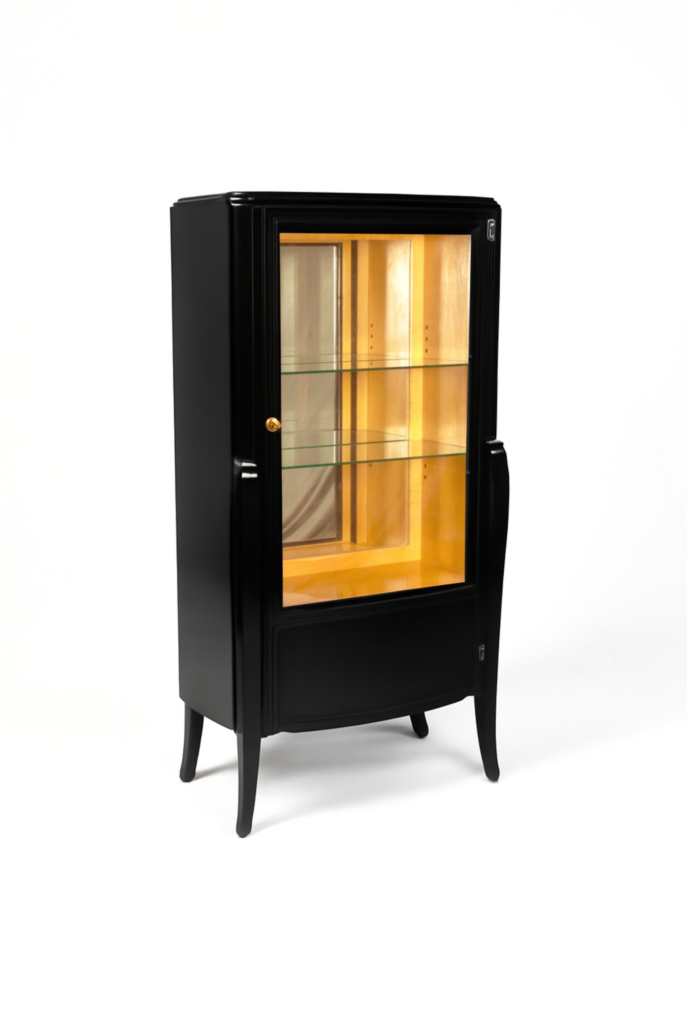 This elegant 1920s French Art Deco  Black Lacquer  vitrine has refined geometric lines and is illuminated internally, creating a warm and intimate projection, enhancing the presentation of your cherished items.

The cabinet features a mirrored back