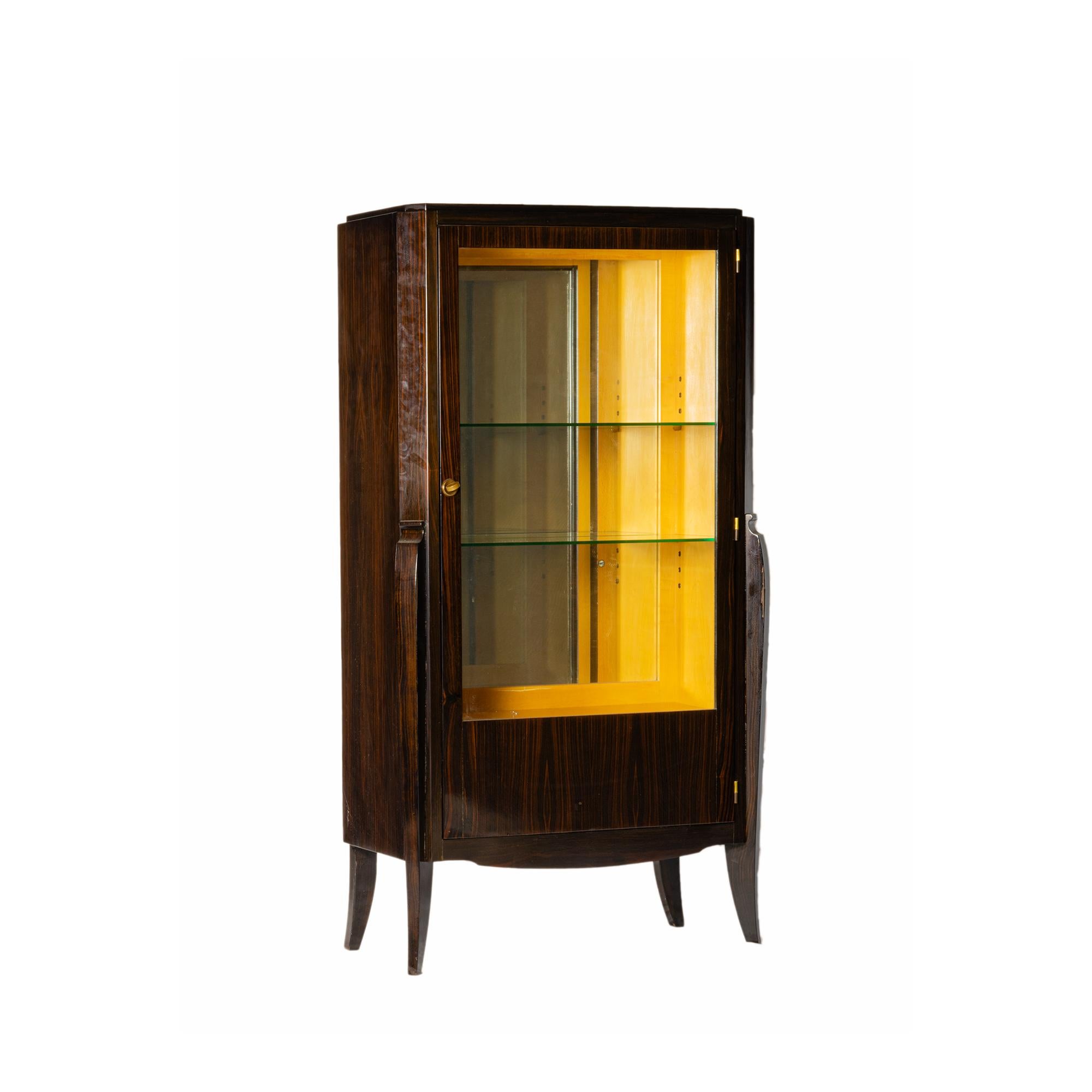 This elegant 1920s French Art Deco vitrine has refined geometric lines and is illuminated internally, creating a warm and intimate projection, enhancing the presentation of your cherished items.

The cabinet features a mirrored back and glass