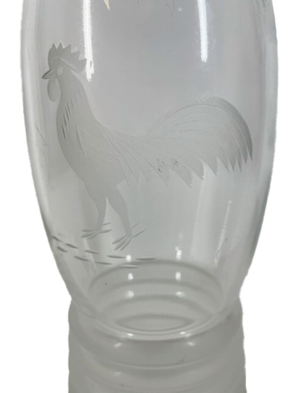 Art Deco clear glass cocktail shaker with center-pour chrome lid. The body of the shaker with a wheel cut image of a rooster above a flared, molded base of rings with a frosted surface.