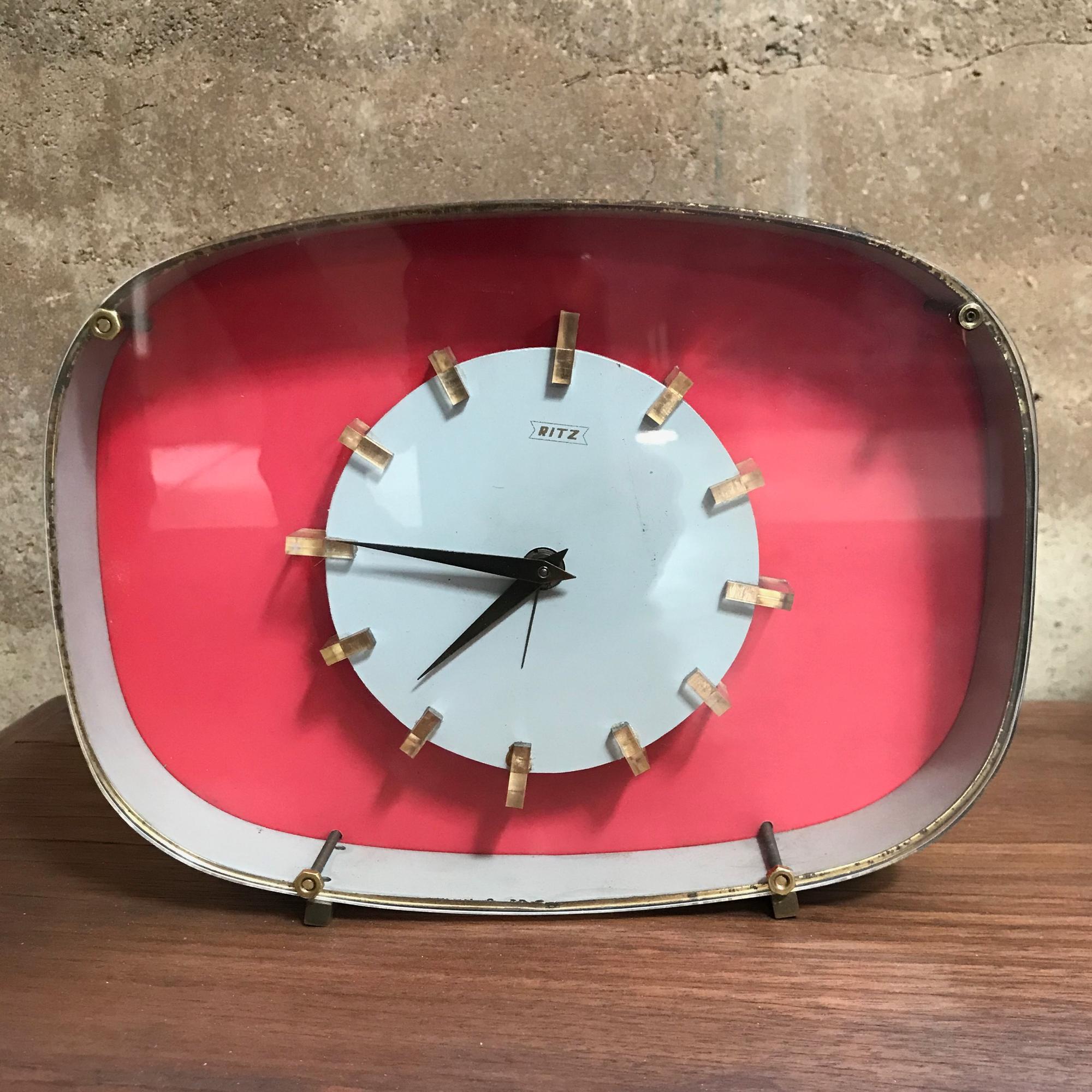 For your consideration: Art Deco fabulous pink vintage table clock by RITZ, made Italy, 1960s

Mechanical wind up alarm desk clock

Colors of pink salmon, white, black, and gold in brass and Lucite plexiglass.

Time markers have Lucite trim.

Table
